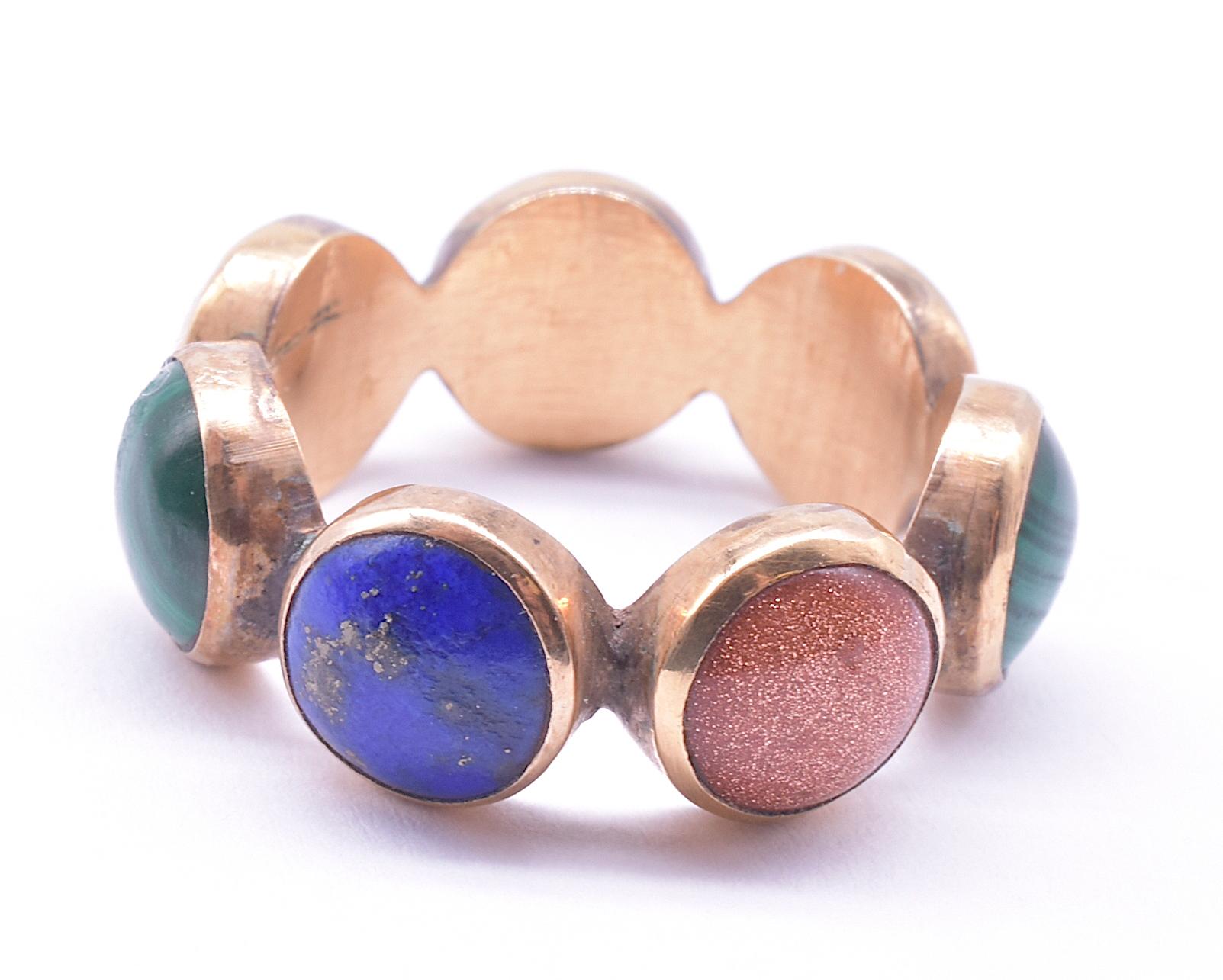 Our rare Georgian planetary ring is made up of seven stones cut and polished en cabochon; 2 lapiz lazuli (blue),  2 goldstone (glass with copper flecks), 2 malachite (green) and one red agate. The deep colors of the stone make this ring mesmerizing.