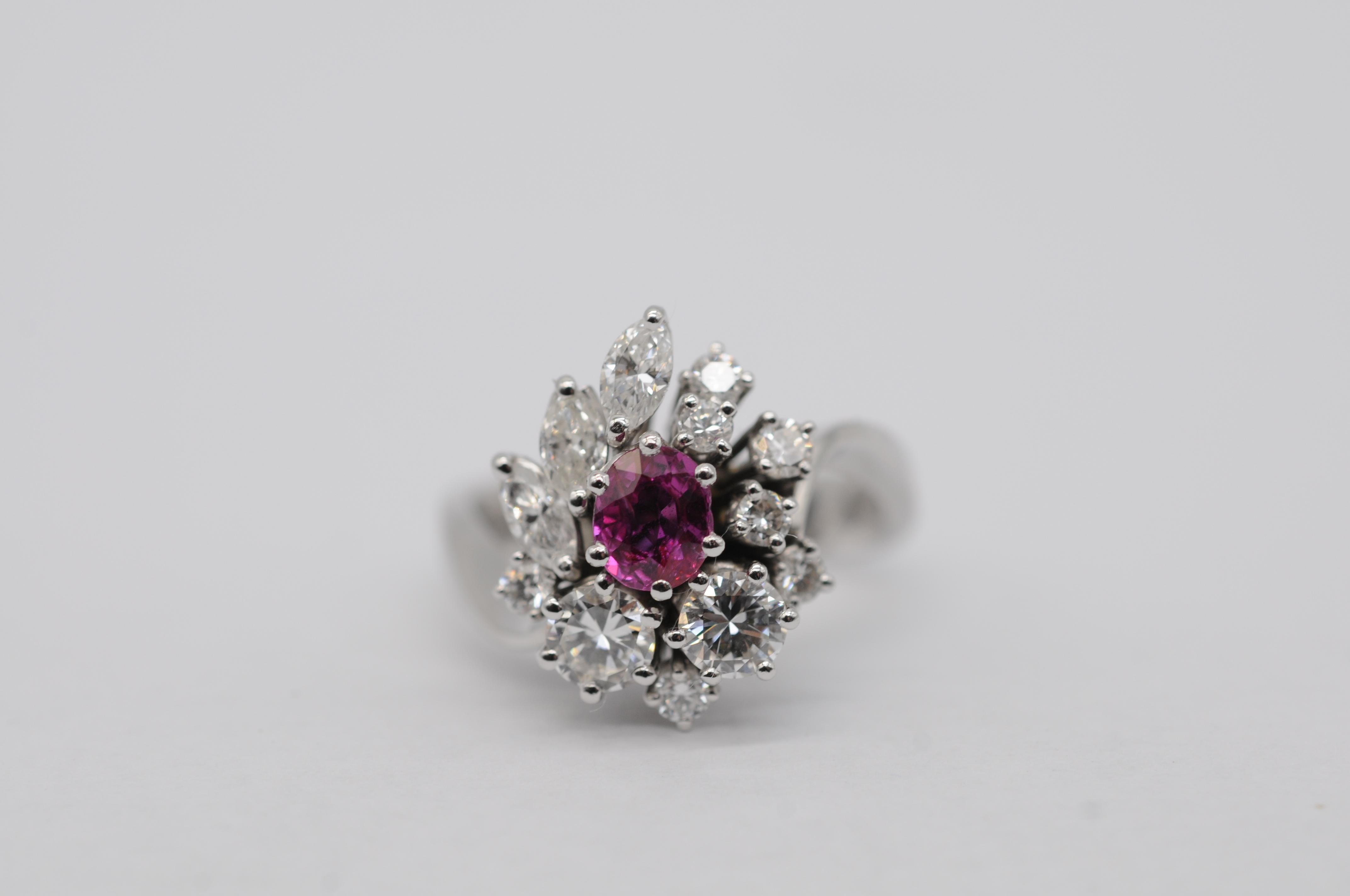 Magnifique bague en or 18 carats ornée de pierres fines, dont un rubis naturel non traité, pesant environ 0,50 carat, est la pièce maîtresse. Le rubis est entouré de 12 diamants étincelants : deux diamants taille brillant, pesant chacun environ 0,20