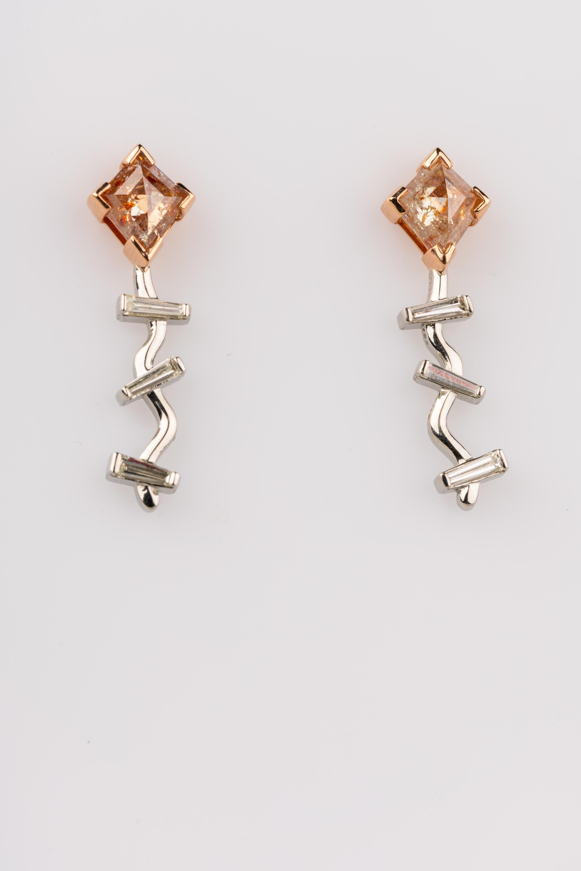 A pair of 18k rose and white gold kite earrings set with 2.04 total carats of kite shaped reddish rose cut diamonds, and .11 total carats of baguette diamonds, F color VS clarity. These earring were made and designed by llyn strong.