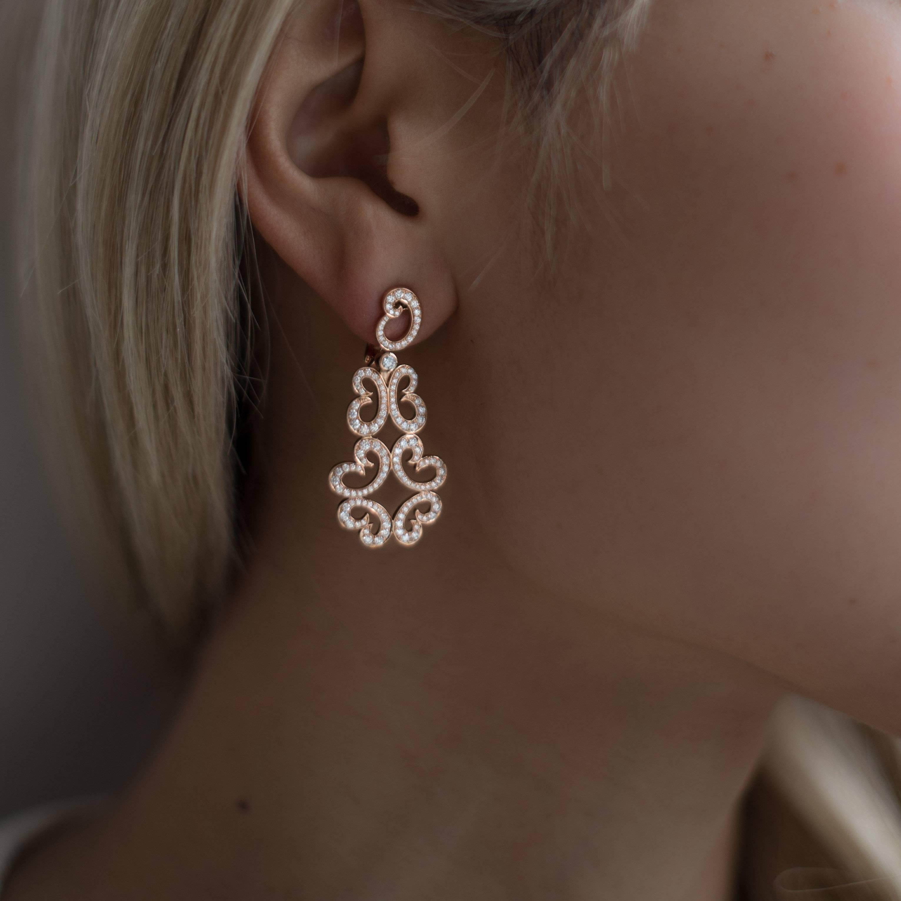 These 18k rose gold scroll earrings feature 268 round brilliant cut diamonds that total 1.33cts. 

The post can be pushed down to accommodate non- pierced ears and the back is a spring- back Omega closure. Your purchase includes an insurance