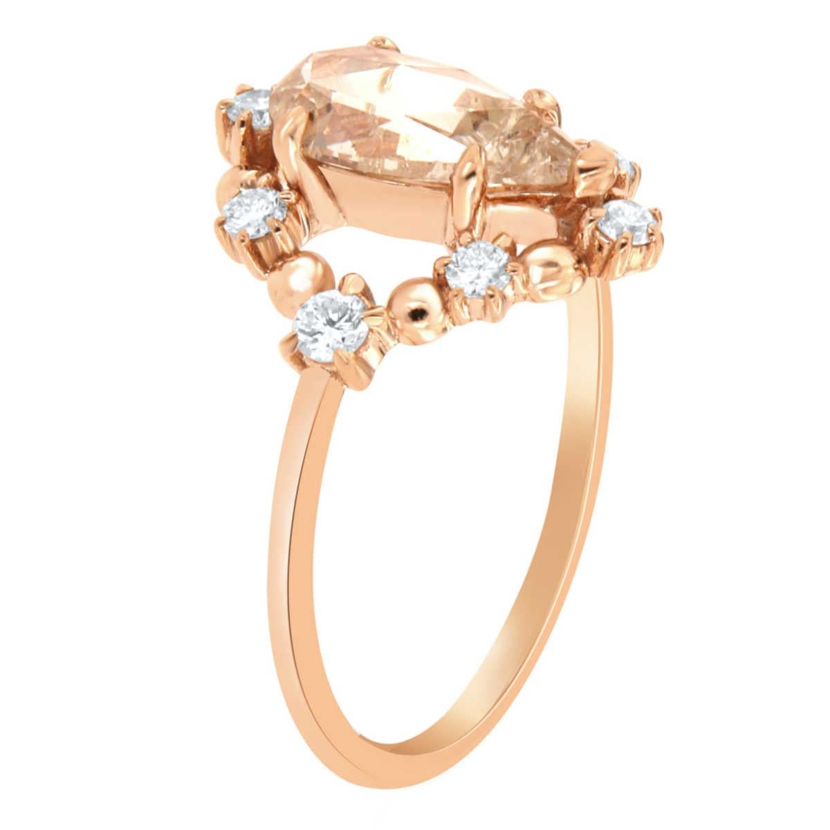 This 18k Rose gold delicate rustic ring features a 1.10 Carat Pear shape faceted brilliant light champagne color Natural Diamond encircled by a scattered halo of eight (8) brilliant round diamonds on top of a 1.3 MM wide band. 
The total diamond