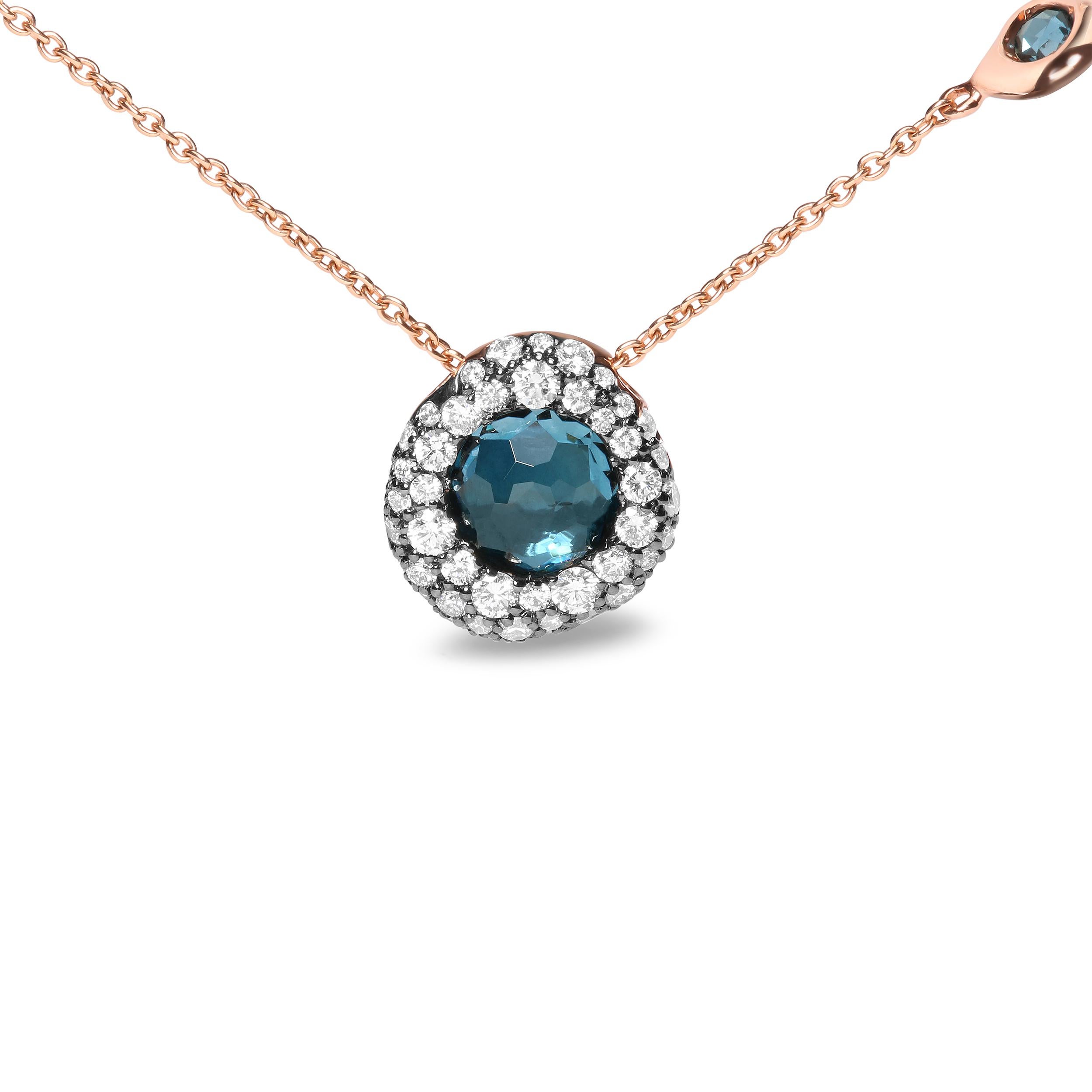 This exceptional 18k rose gold station necklace features a natural 7.7mm round bezel-set topaz in a vivid heat-treated  London blue hue that serves as an eye-catching centerpiece. A cluster of round, bezel-set diamonds encircles this crisply colored