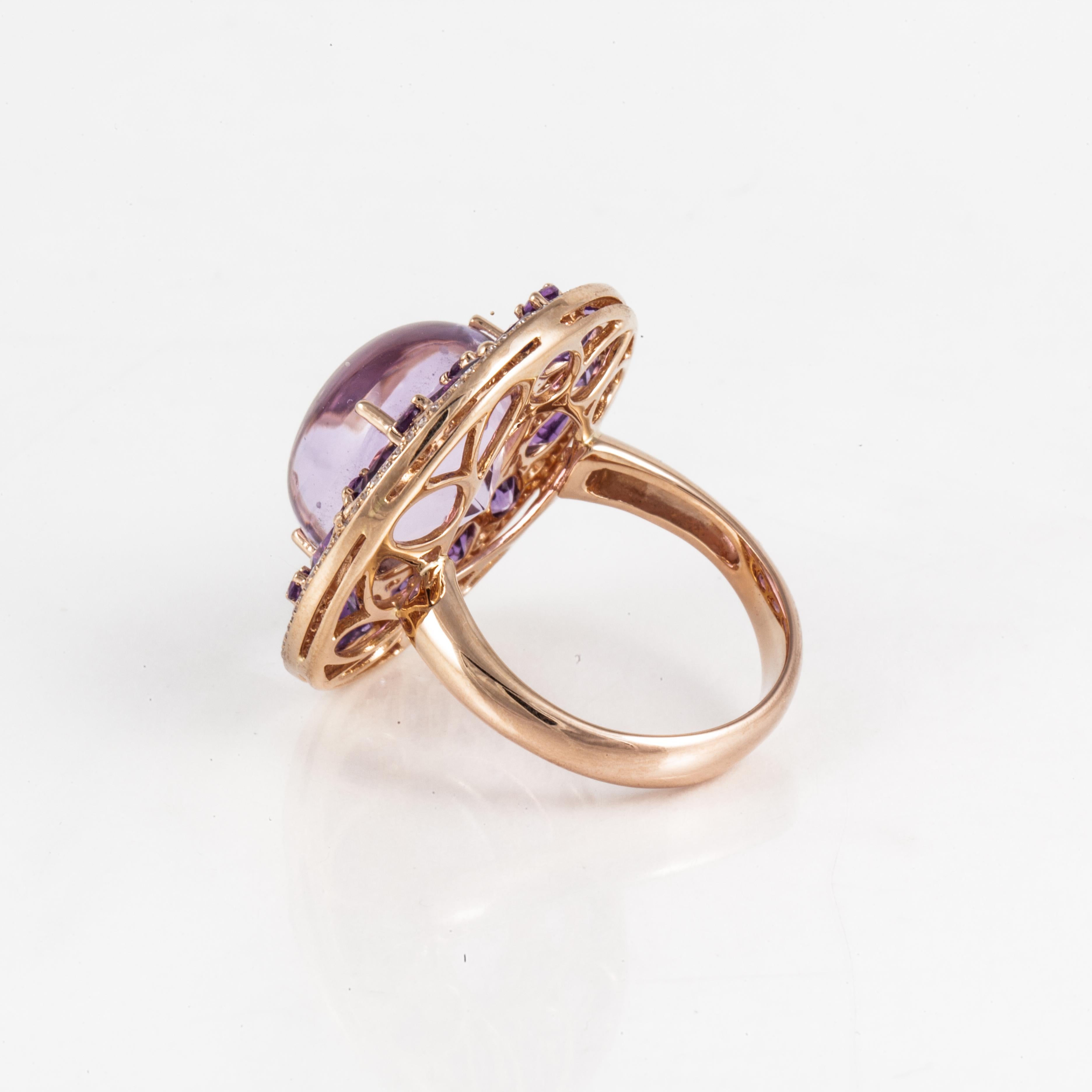 18K rose gold ring featuring a round cabochon amethyst framed by 22 faceted amethysts and then framed by 88 single-cut diamonds. The diamonds total 0.50 carats.  The ring measures 1 inch in diameter and sits 1/2 inch off the finger.