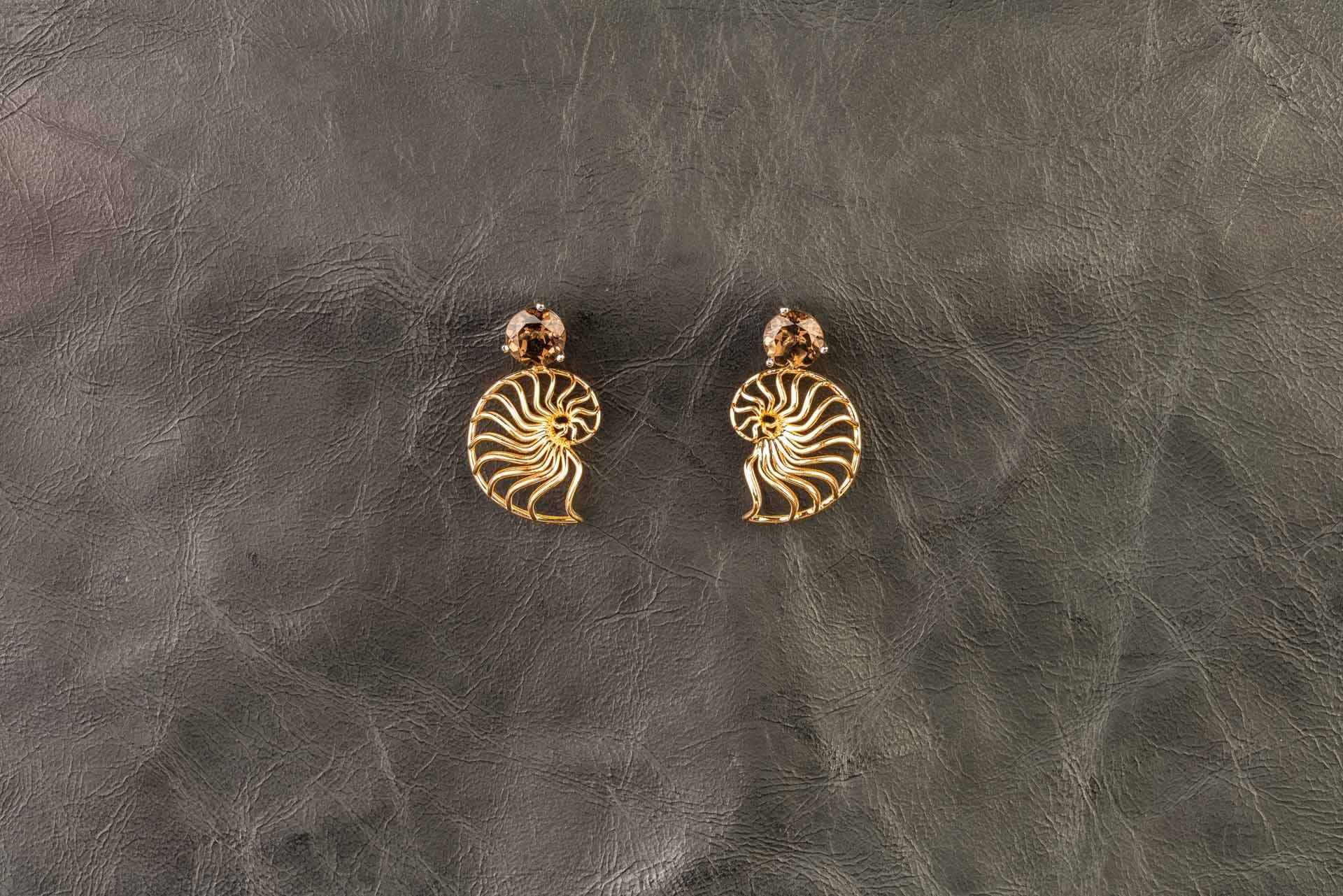 A pair of 18k rose gold three dimensional ammonite earring jackets, on a pair of 18k white gold martini head studs set with 8mm round smoky quartz. These earrings were made and designed by llyn strong.
Items can be priced separately upon request.