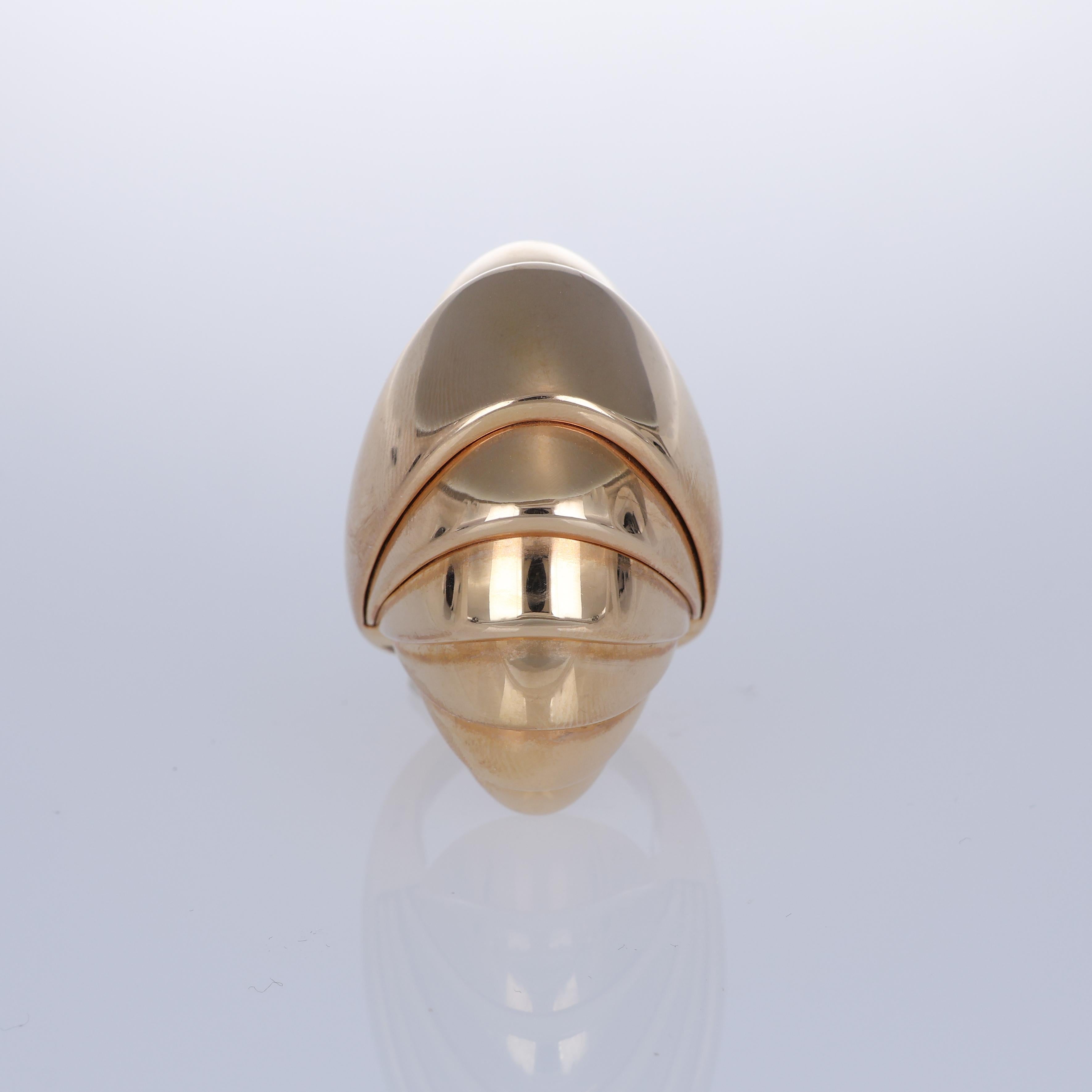 A bold and sculptural piece, this ring is crafted in polished 18K rose gold, designed with a unique armadillo-inspired form. Its smooth, reflective finish enhances the modern and distinctive silhouette, making it a statement accessory for the