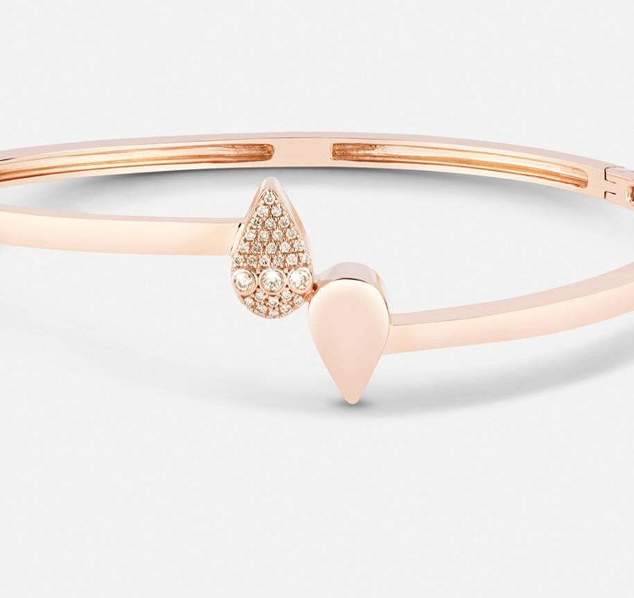 Eleganza e raffinatezza si fondono in un perfetto equilibrio: questo bracciale dal design raffinato presenta due gocce in direzioni opposte, creando un'accattivante simmetria visiva. Una goccia è impreziosita da diamanti scintillanti, mentre l'altra