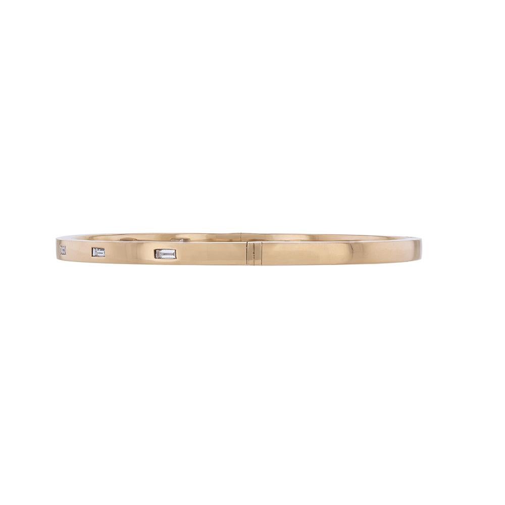 This bangle is made in 18K rose gold and features 7 baguette cut, bezel set diamonds weighing 0.28 carat. This bangle has a color grade (H) and a clarity grade of SI2.