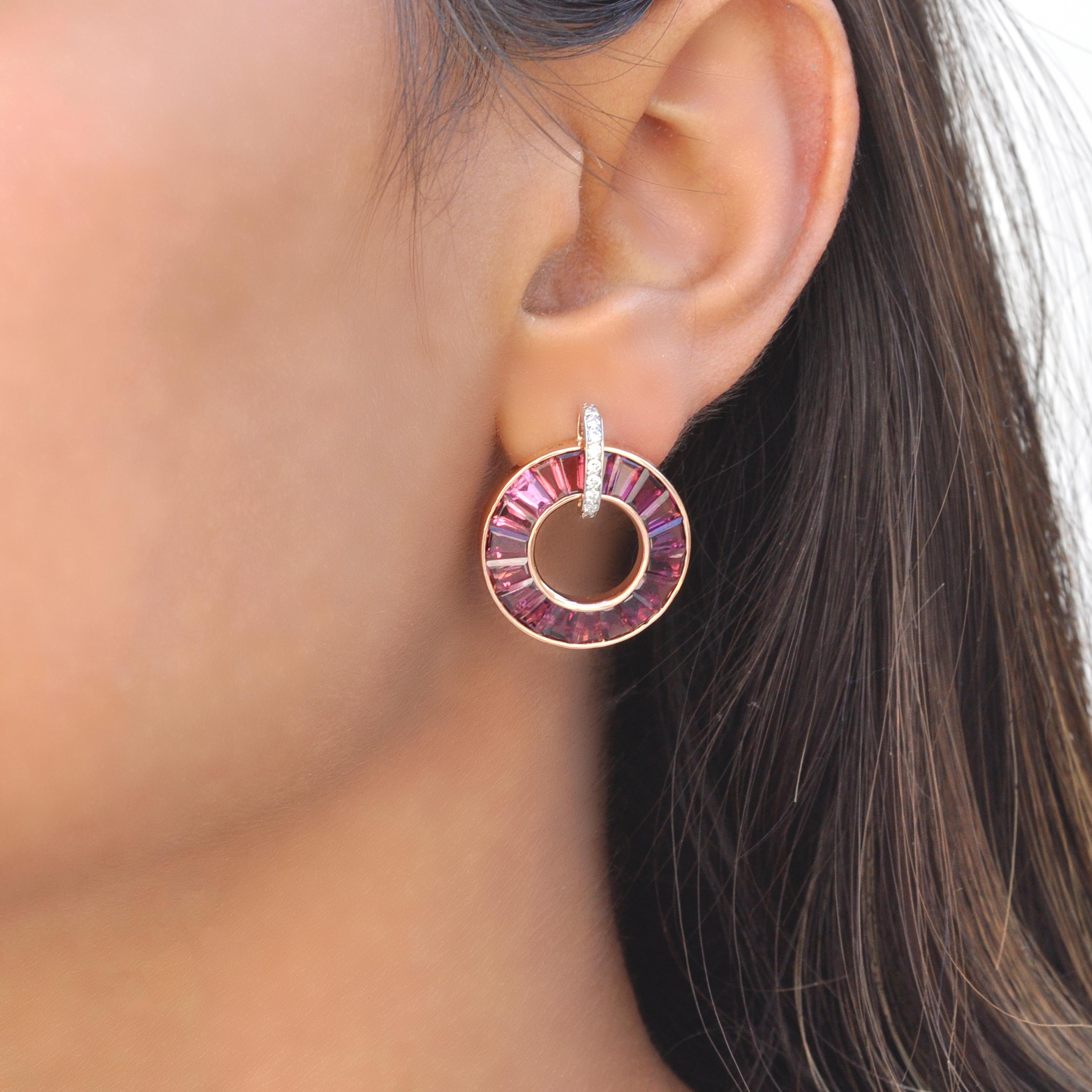 18K rose gold rhodolite garnet diamond circle earrings are fusion of opulence and sophistication. Crafted in lustrous 18-karat rose gold, these earrings feature tapered baguettes rhodolites cradled in a loop adorned with pave-set diamonds, creating