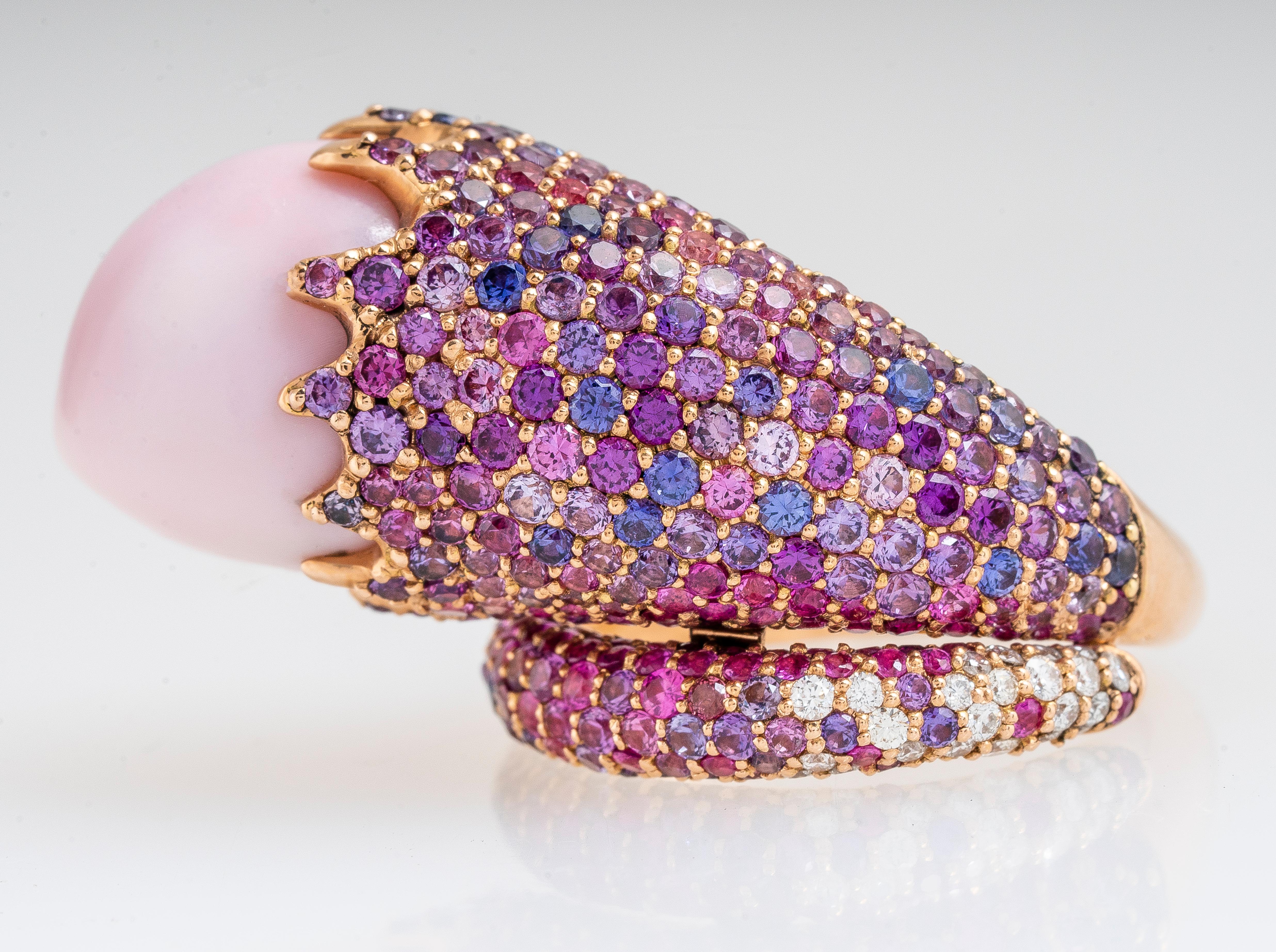 18k rose gold pink conch and multi-color pink to purple sapphire pave snake shaped ring.  Conch pearl measures 15.51 x 14.32 x 13.43 mm.  Approximately 9.50 carat total weight of 326 round pink to purple sapphires and 0.50 carat total weight  RBC