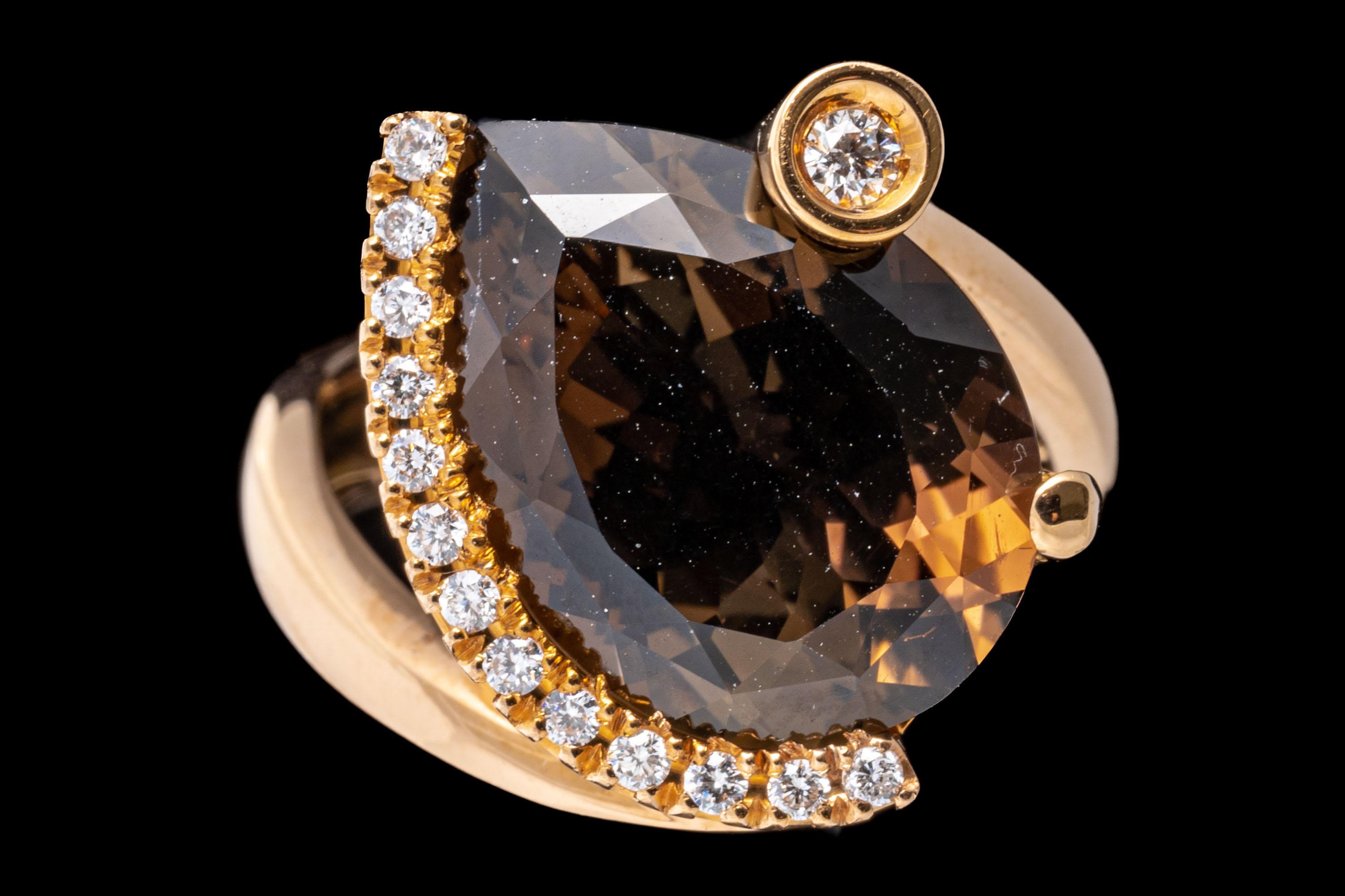18k rose gold ring. This gorgeous contemporary features a pear shaped faceted, dark brown color smoky quartz, approximately 6.68 CTS, surrounded by a half halo of round faceted diamonds. Offsetting the halo, and acting as a decorated prong is a
