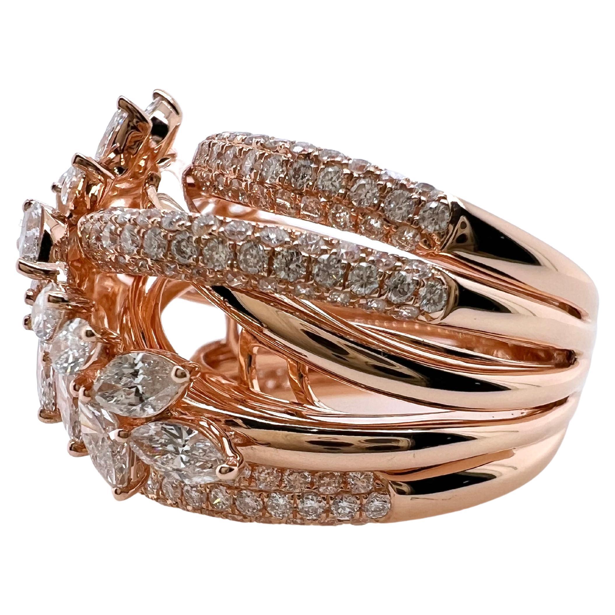 Das elegante Design dieses maßgefertigten Rings wird alle Blicke auf sich ziehen.  Die prächtigen Marquise-Diamanten sind in einer Art Kranz gefasst, der auf Reihen von runden Brillantbändern sitzt.  Das Profil sitzt höher und verleiht ihm eine