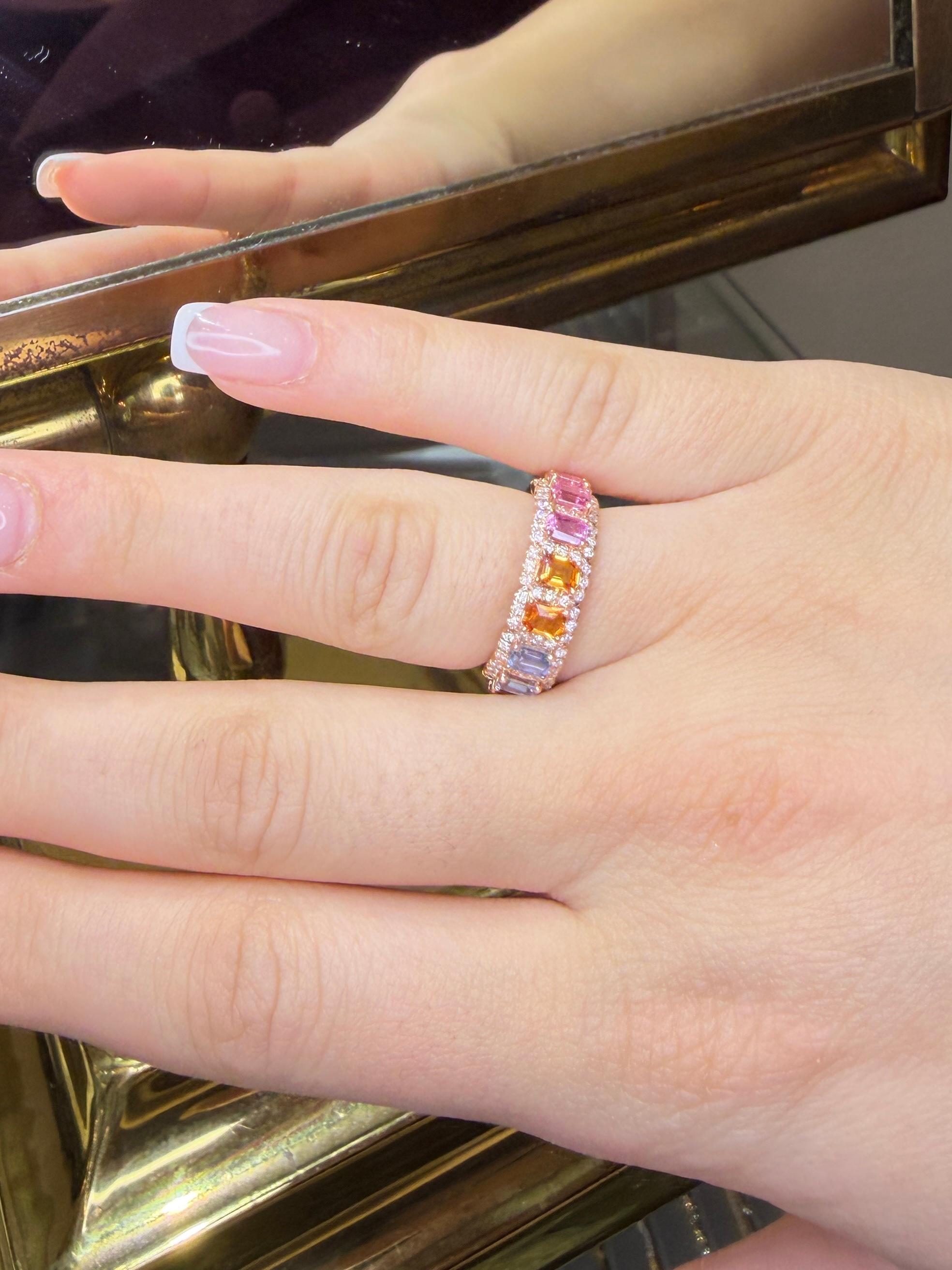 Cette bague en saphir et diamant multicolore en or rose 18 carats est une version moderne et vibrante du bracelet d'éternité classique. Elle présente un cercle complet de saphirs de Ceylan naturels, taillés en émeraude, dans une palette arc-en-ciel