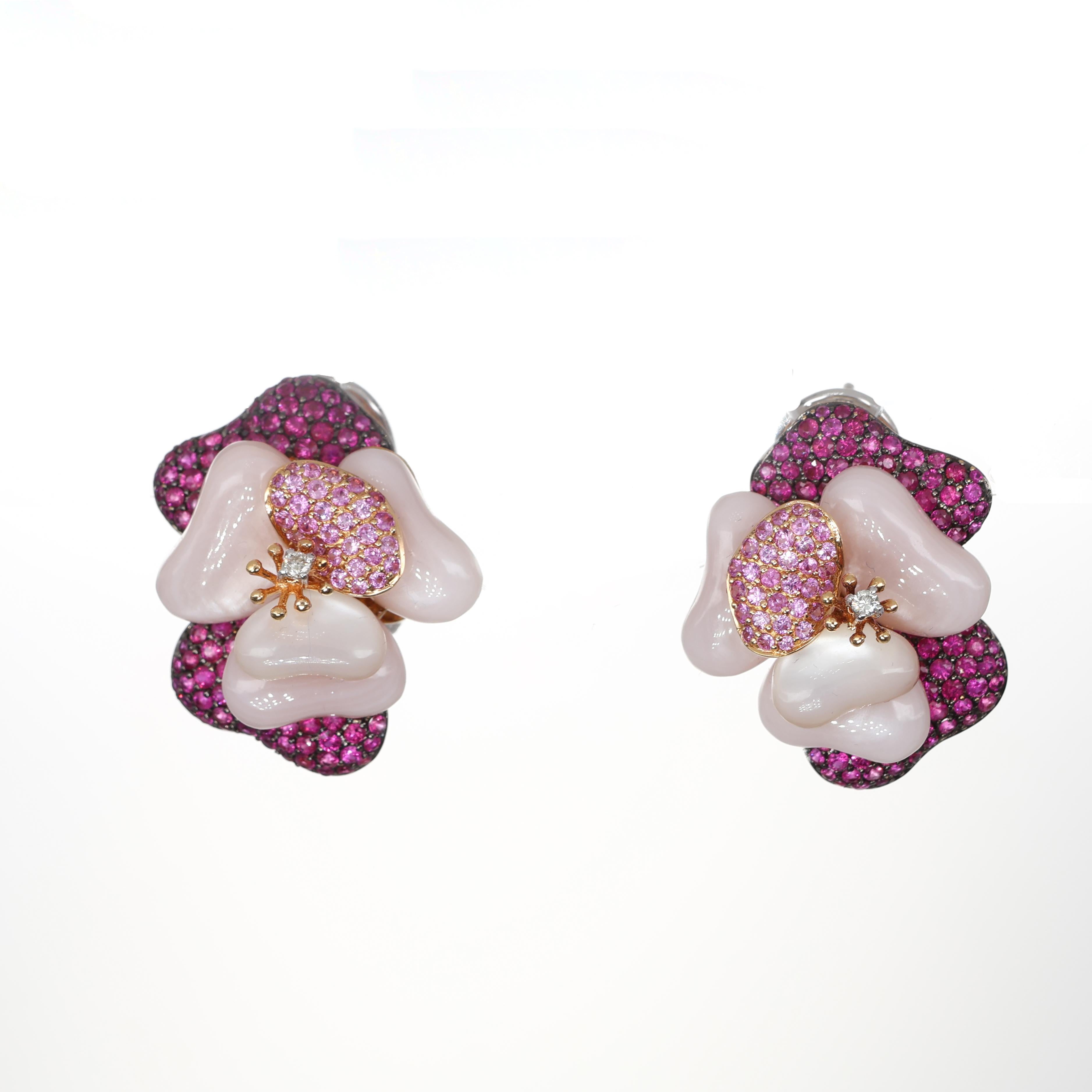 These exquisite 18K rose gold earrings celebrate the beauty of nature with an intricate floral motif. The petals are sculpted from luminous mother-of-pearl, creating a delicate and organic shape. A pavé of vibrant pink sapphires forms the