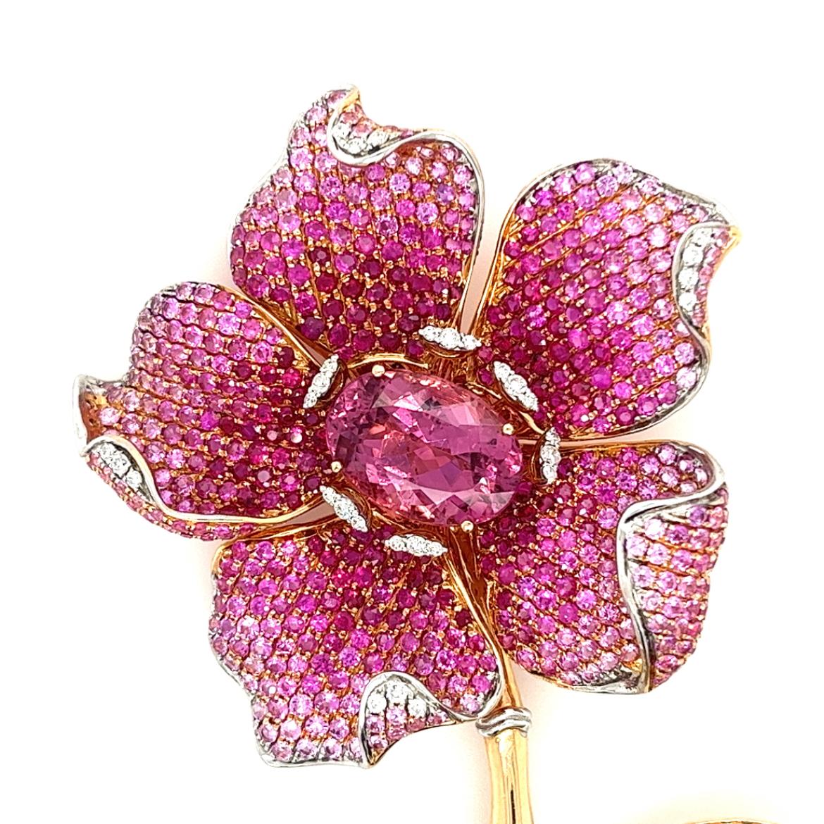18K Rose Gold Flower Brooch with
Diamonds & Rubies & Pink Sapphires
32 Diamonds - 0.78 CT
56 Green Garnets - 1.16 CT
1 Tourmaline - 7.48 CT
535 Rubies/Pink Sapphires - 9.97 CT
18K Rose Gold - 23.43 GM

Indulge in the timeless elegance of our 18K