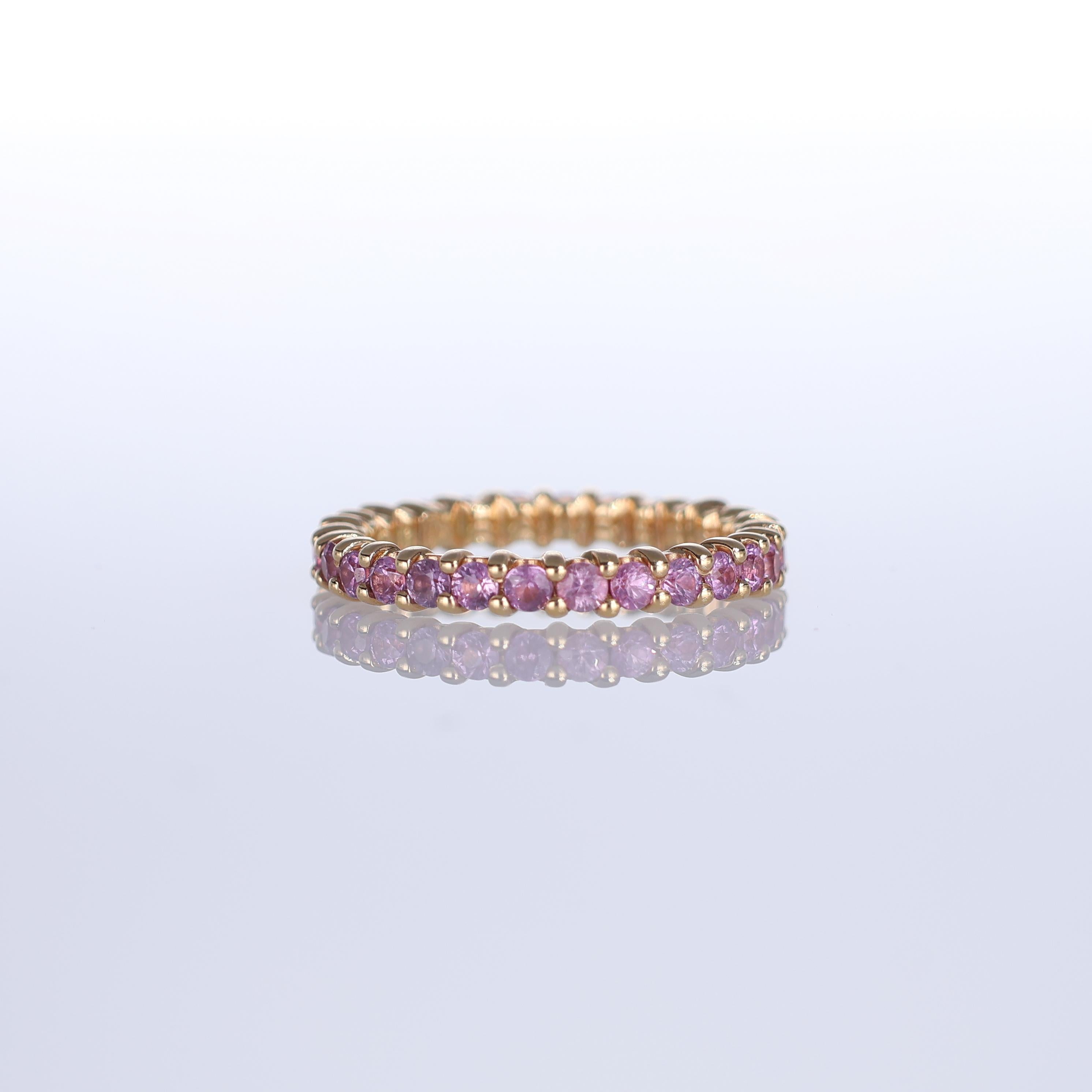A refined eternity band crafted in 18K rose gold, fully set with a continuous row of vibrant pink sapphires totaling 1.75 carats. The delicate prong setting enhances the brilliance of each gemstone, creating a timeless piece that exudes elegance.