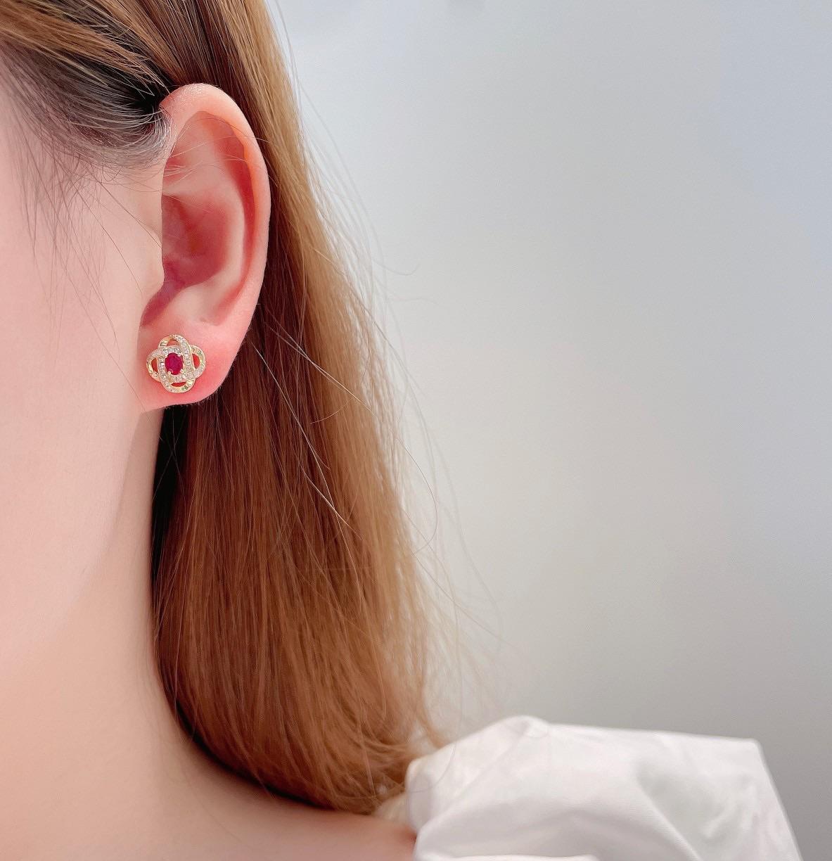 Questi orecchini a perno in oro rosa 18 carati presentano un design audace e contemporaneo, con un rubino naturale dal taglio brillante (0,38 carati) incastonato in un'intricata struttura traforata. Eleganza di diamanti naturali a taglio rotondo