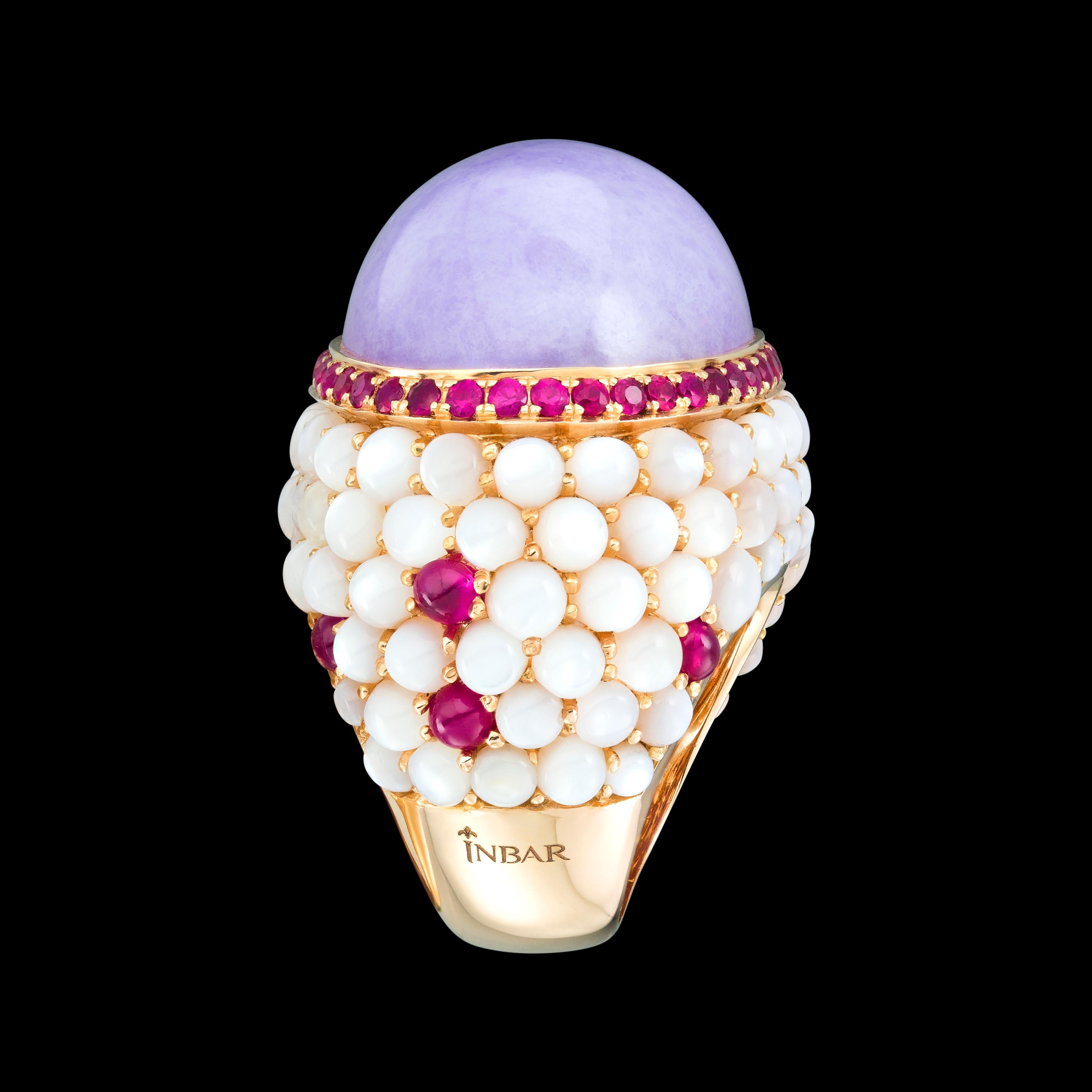 A large center stone, cabushin cut, 18k gold, lavender jade with rubies and mother of pearl.