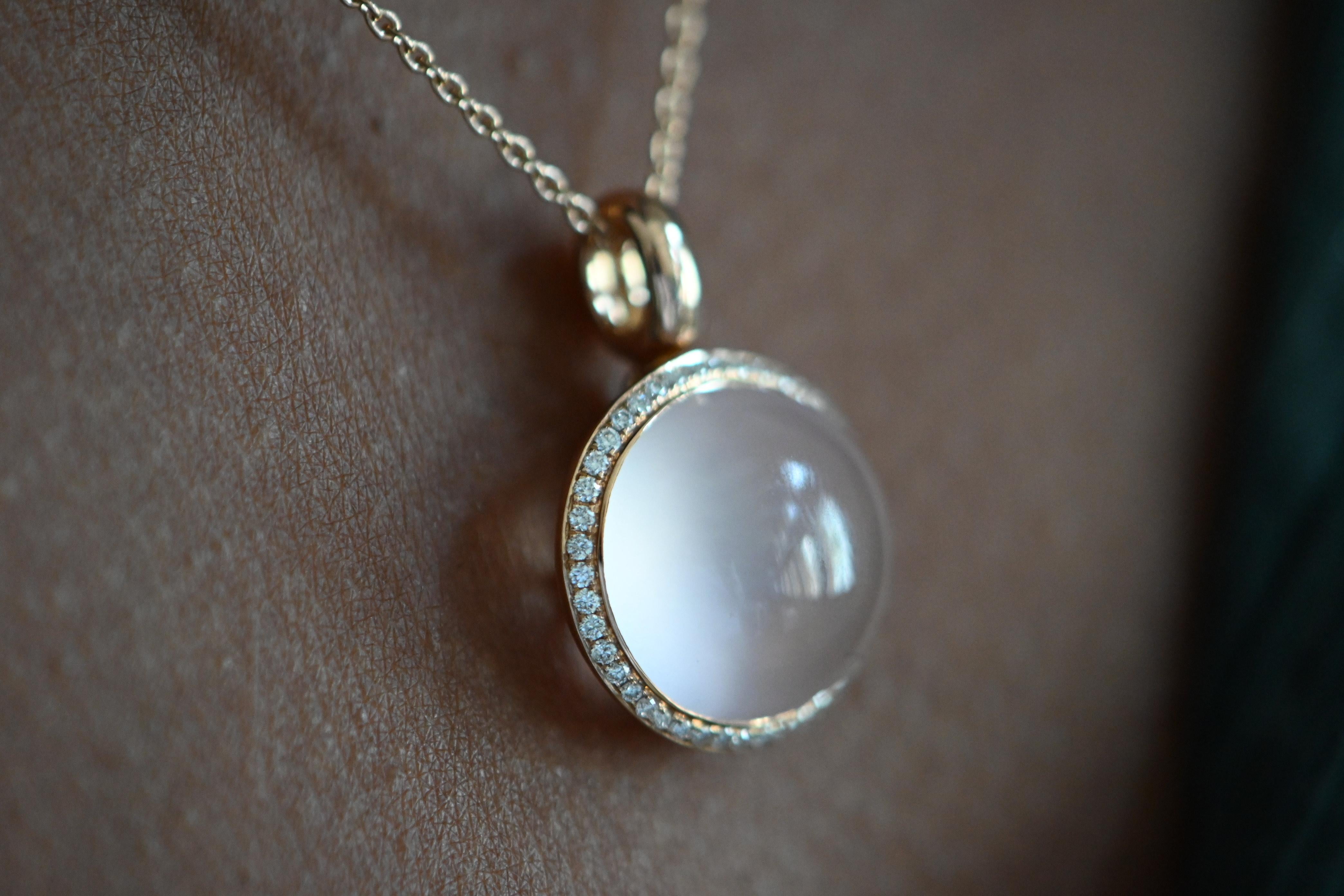 
This refined 18K rose gold necklace showcases a delicate and elegant pendant design, featuring a soft, powdery-hued cabochon rose quartz of 7.30 carats. The central gemstone is beautifully framed by a halo of 43 sparkling diamonds, offering a