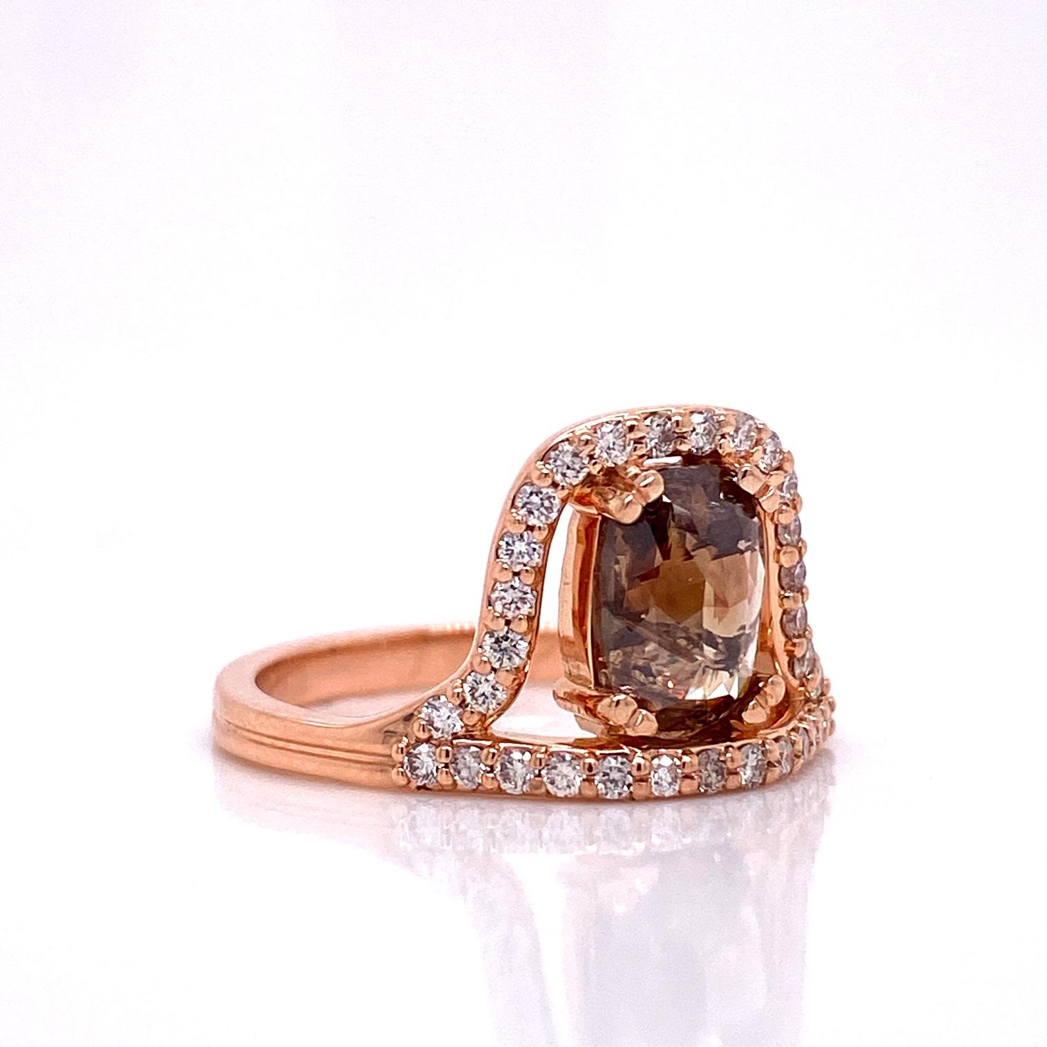 An 18k rose gold ring with one 1.045 carat rose cut cognac diamond surrounded by .31 carats of 1.3mm round top light brown diamonds. Ring size 7. This ring was made and designed by llyn strong.