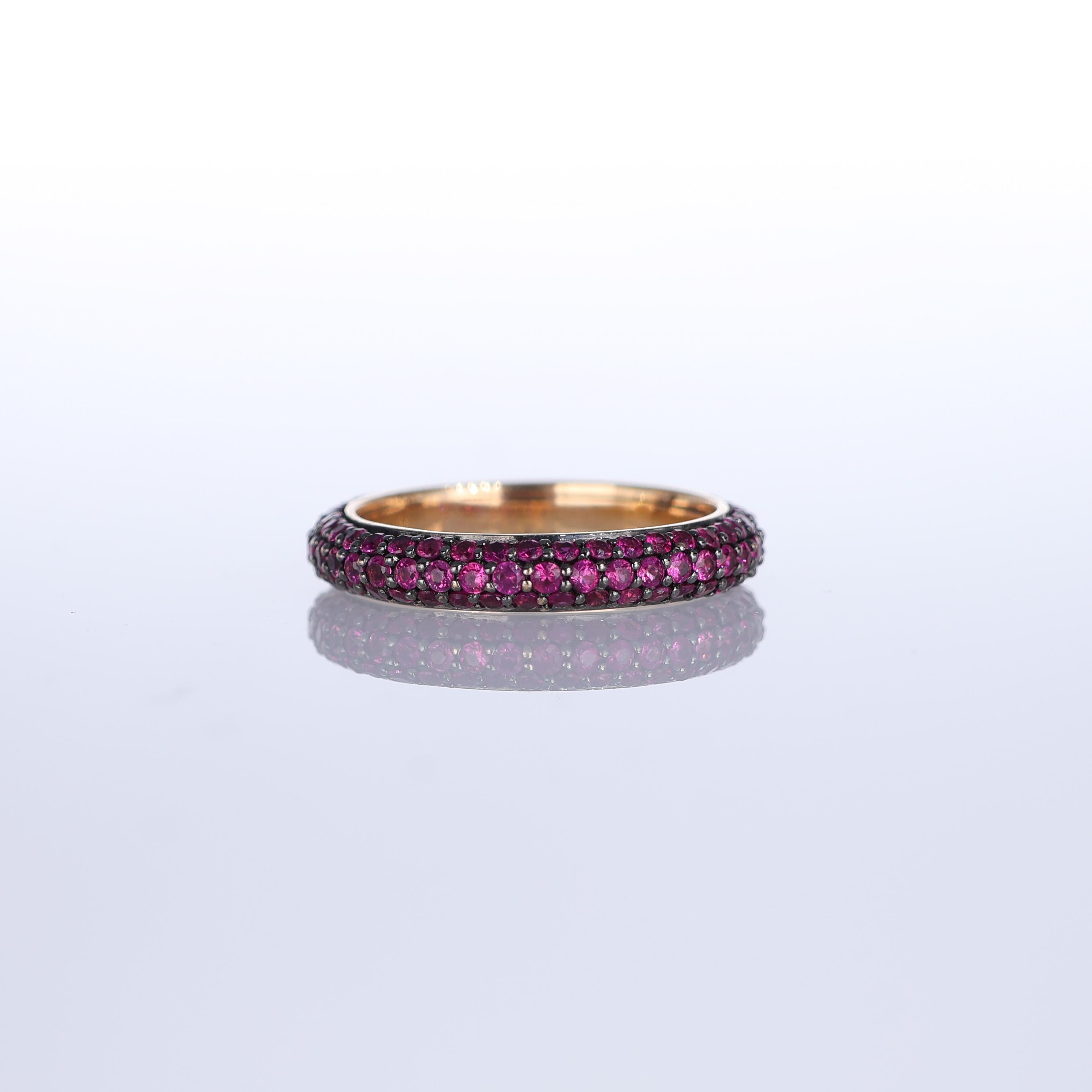 A refined eternity band in 18K rose gold, featuring a pavé setting of vibrant rubies totaling 1.62 carats. The deep red hue of the gemstones contrasts beautifully with the warm gold, creating a sophisticated and timeless piece. Designed for stacking