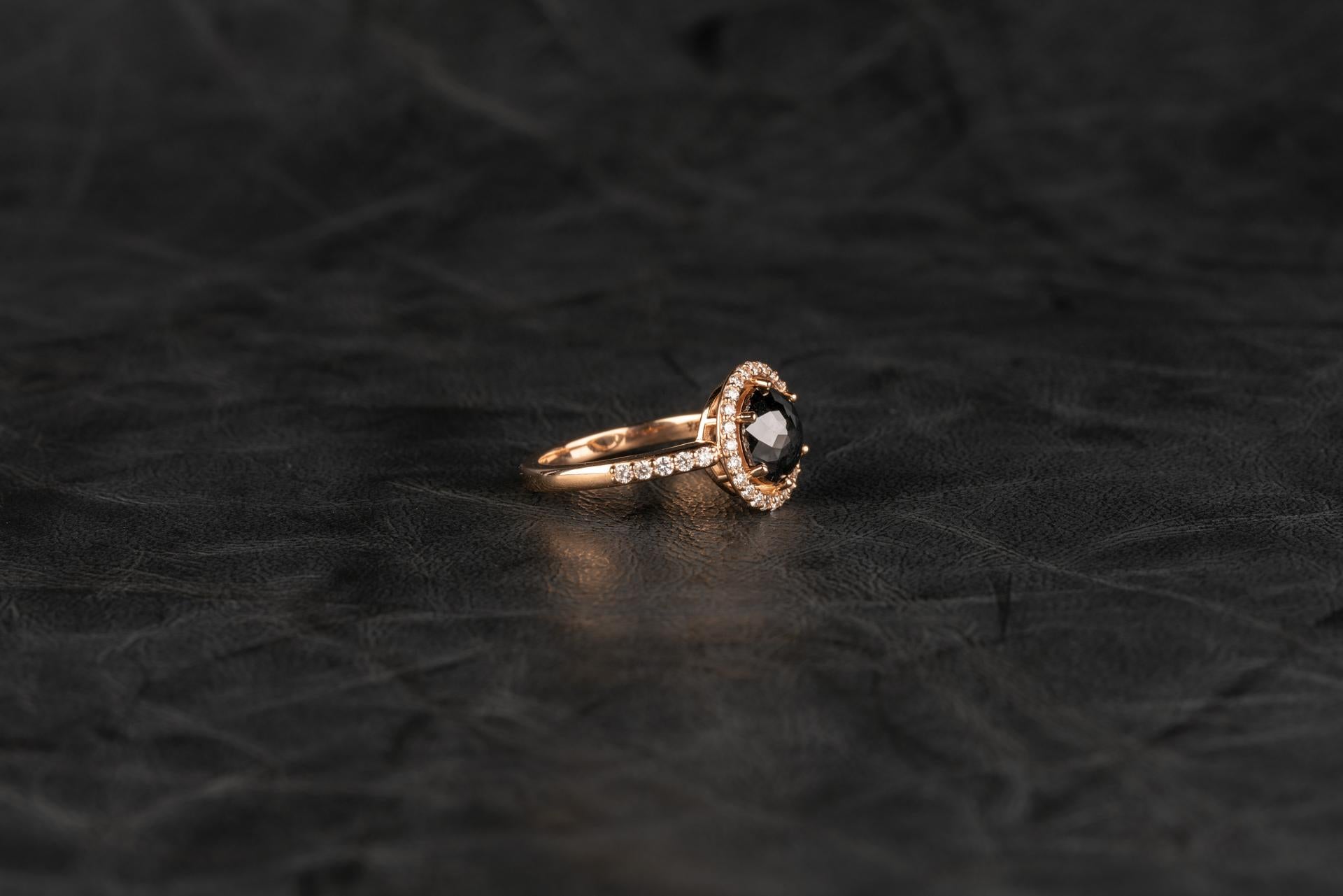 An 18k rose gold ring featuring one rose cut black diamond, 2.53 carats, and 0.37 total carat weight champagne diamonds in the halo and down the sides of the shank, ring size 7.  This ring was custom designed and made by llyn strong.