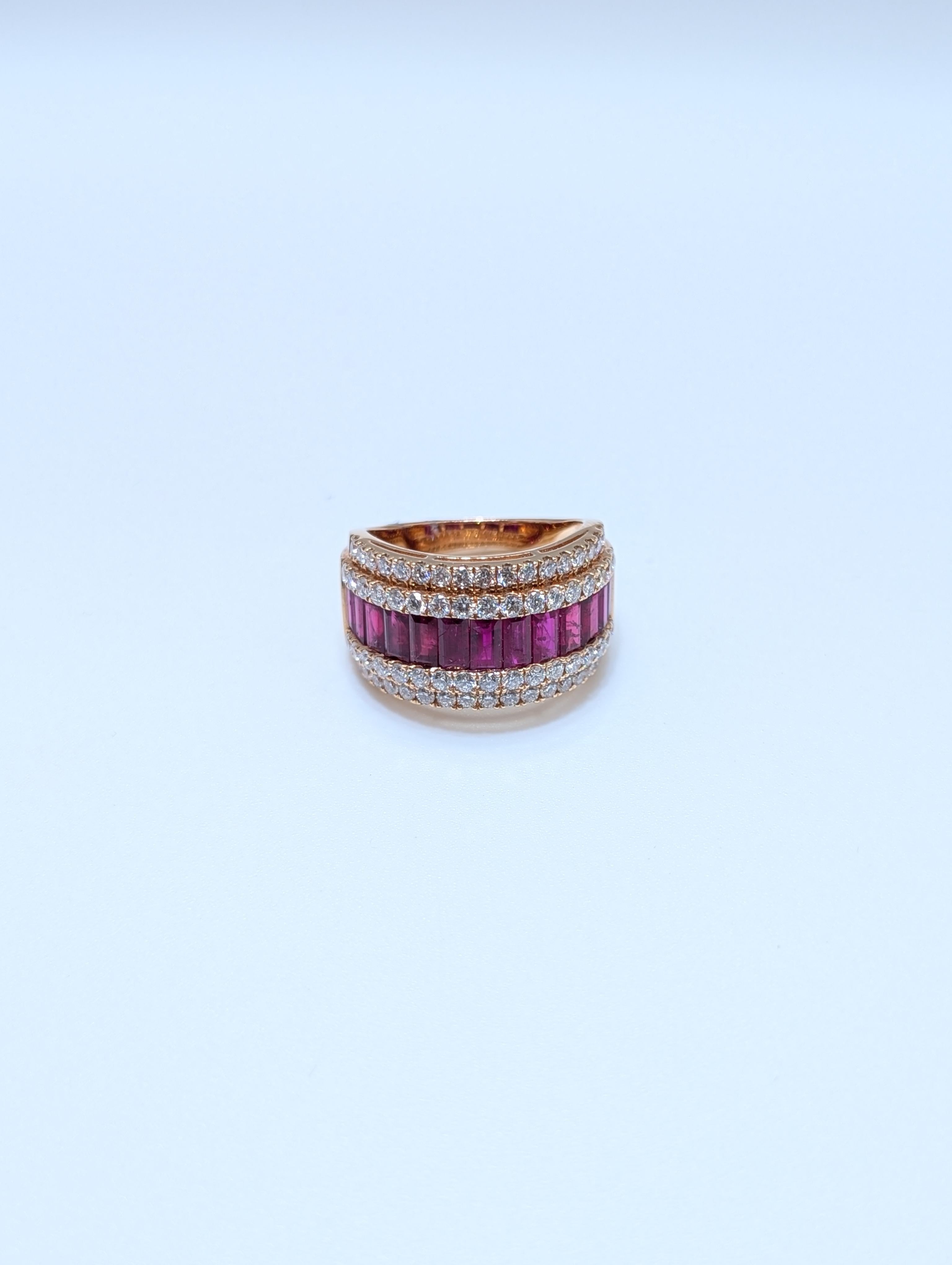 Realizzato in lussuoso oro rosa 18 carati, questo sorprendente anello a fascia larga mostra una squisita miscela di brillantezza e colori vivaci. Due file scintillanti di diamanti a taglio rotondo (1,25 carati di peso totale) incorniciano la parte