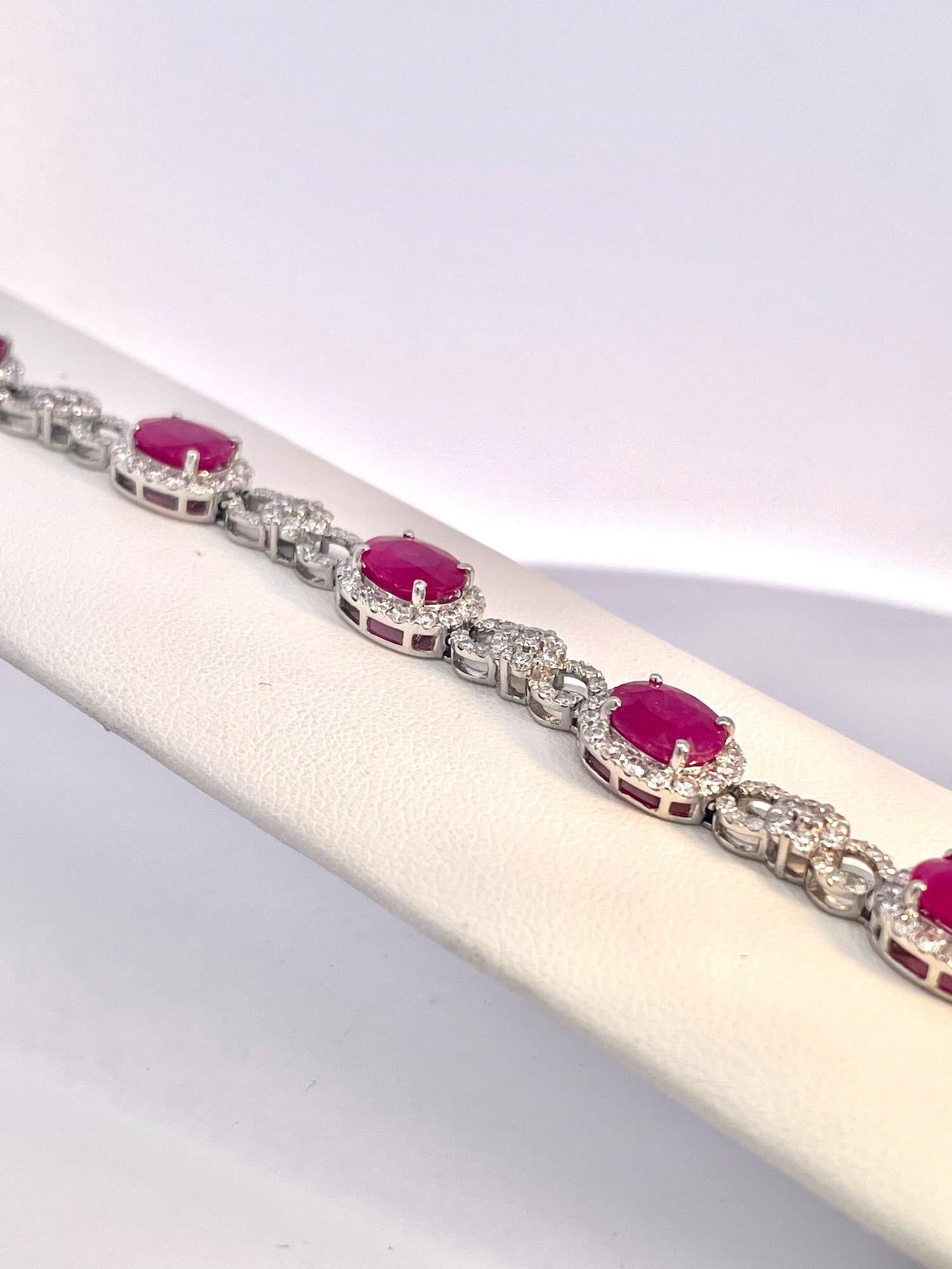 Ce bracelet rubis-diamant est contemporain mais tout simplement magnifique.  Il y a 8 pierres ovales en rubis d'un poids de  16,06 carats plus des diamants de 5,24 carats pour un poids total de 16,00 carats.  Ce bracelet est orné de diamants