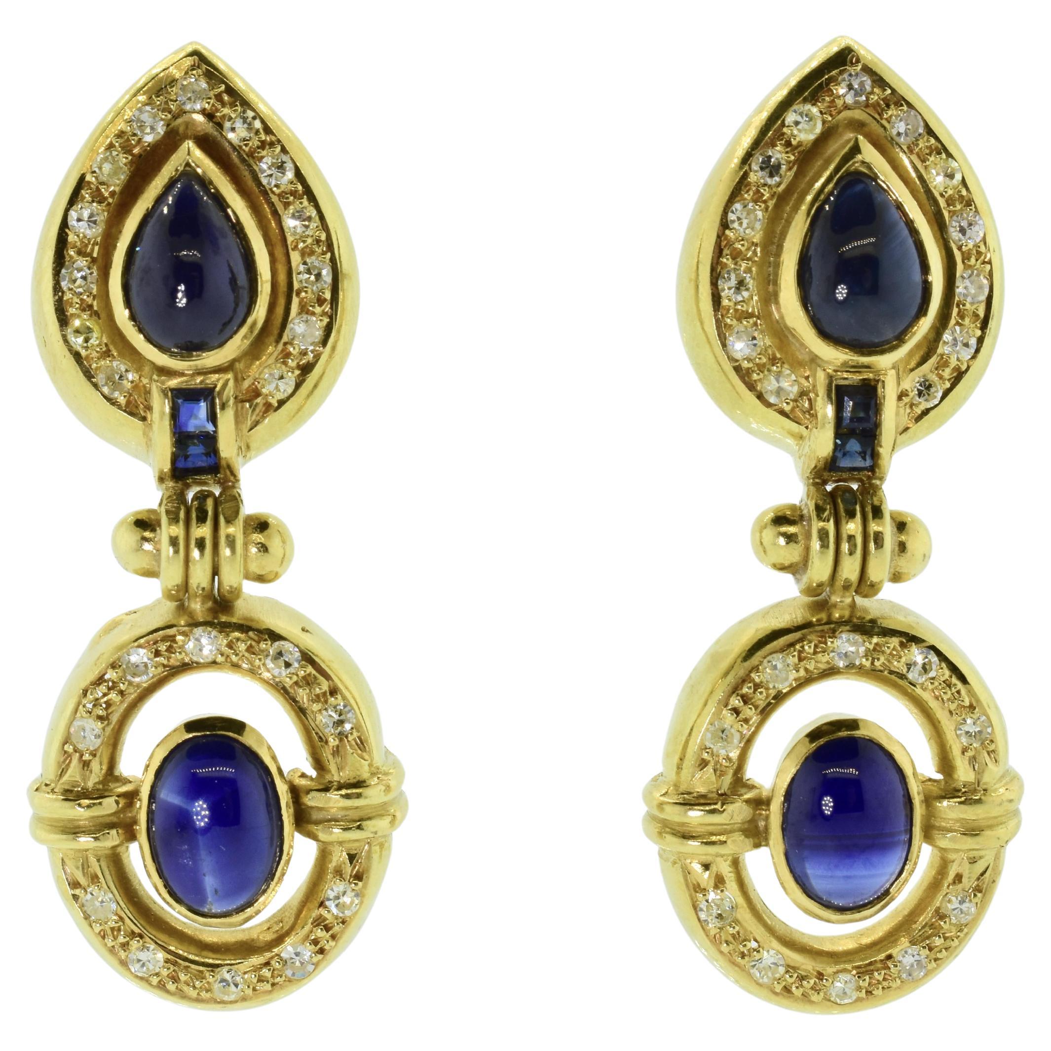 Ohrringe aus 18 Karat Gelbgold mit natürlichen Saphiren im Birnen- und Ovalschliff, die mit weißen Diamanten im Brillantschliff besetzt sind. Diese Ohrringe wiegen 13,3 Gramm, jeder Ohrring besitzt 2 birnenförmige und 2 ovale, im Cabochon-Schliff