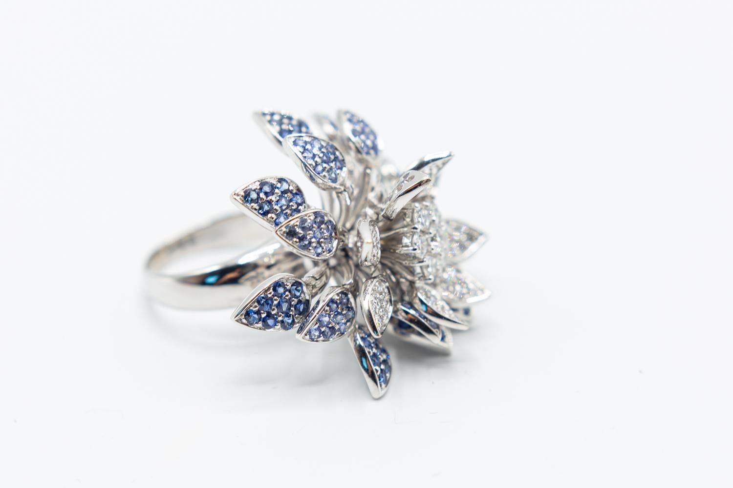 Effy 18K white gold floral cocktail ring featuring 1.49 carats of round brilliant diamonds, 1.28 carats of round brilliant blue sapphires and 0.90 carats of round brilliant light blue sapphires.