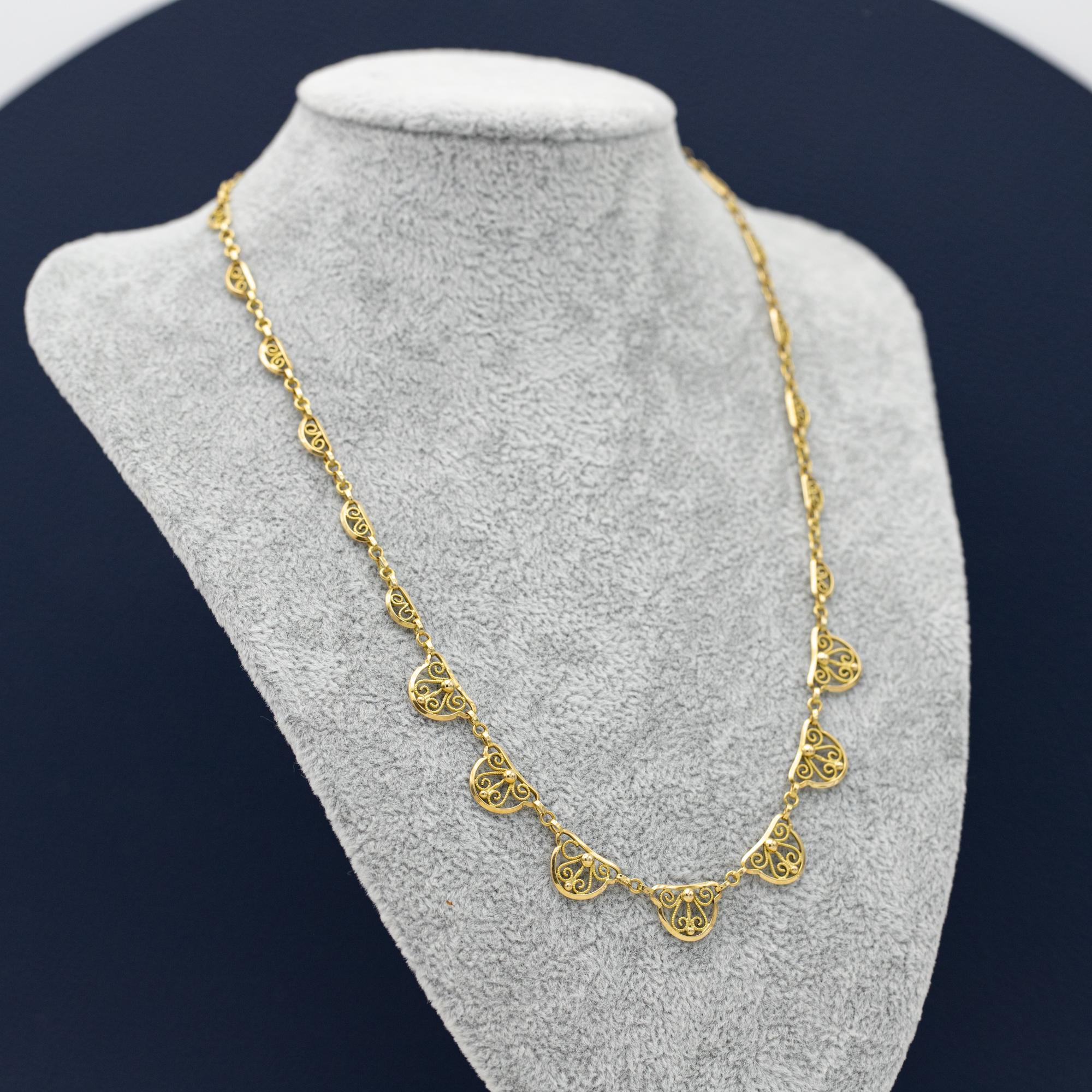 Ce collier en filigrane est réalisé en or jaune 18 carats et orné de sept petits points sur les maillons les plus grands. Les chaînes en filigrane sont très détaillées et à couper le souffle grâce aux volutes élégantes. Les sept grands maillons