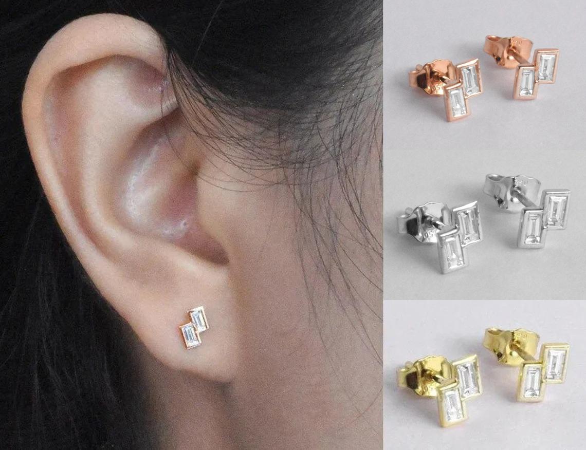 Baguette-Diamant-Ohrstecker aus 18k Roségold, Gelbgold und Weißgold.

Diese zierlichen Ohrstecker sind aus massivem 18-karätigem Gold gefertigt und mit glänzenden, rund geschliffenen Naturdiamanten besetzt, die in unserem Studio von Meisterhand