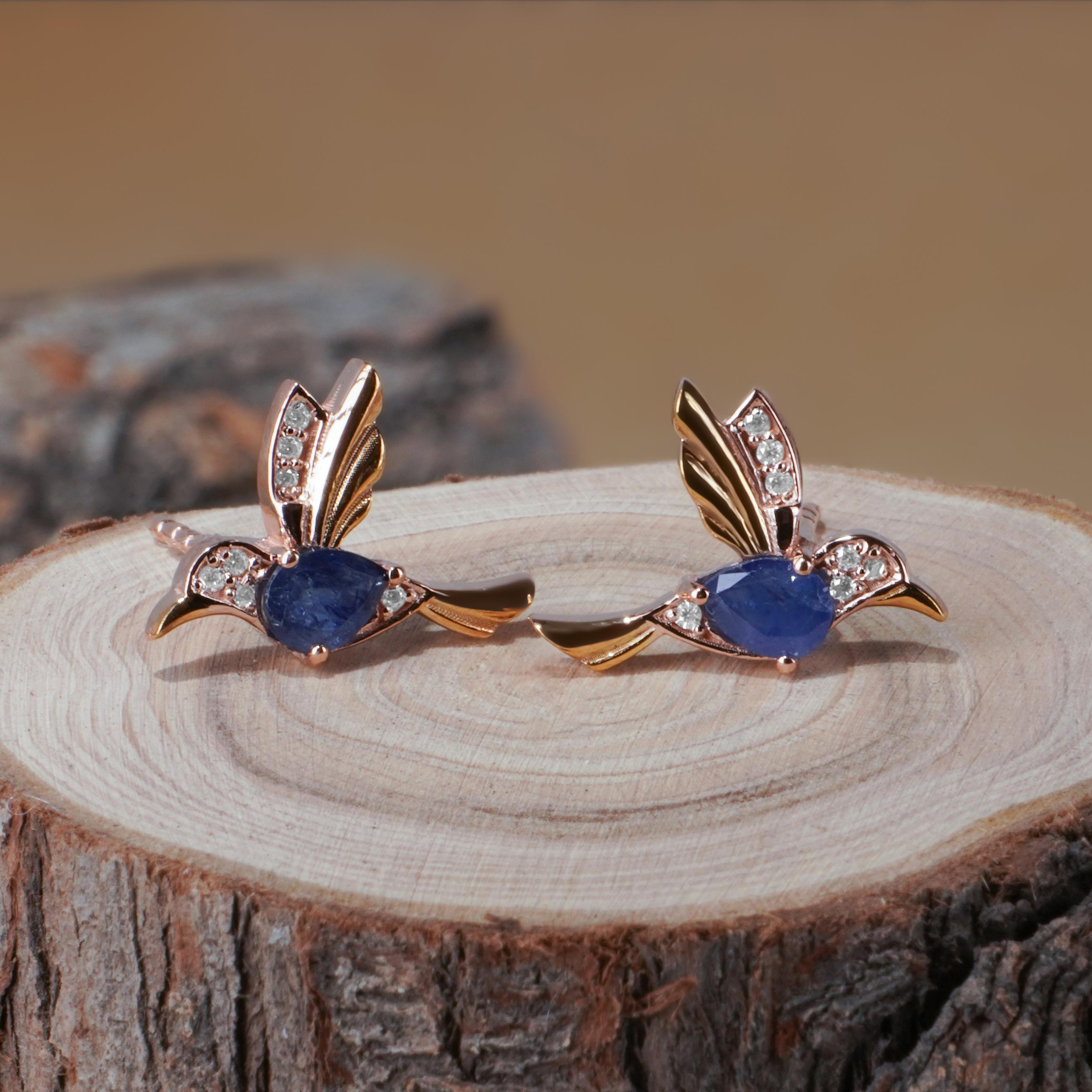 Si vous cherchez une paire de boucles d'oreilles qui vous fera sortir du lot, ne cherchez pas plus loin que les boucles d'oreilles Bird Sapphire and Diamond. Ces boucles d'oreilles sont fabriquées à la main en or massif 18 carats et présentent de