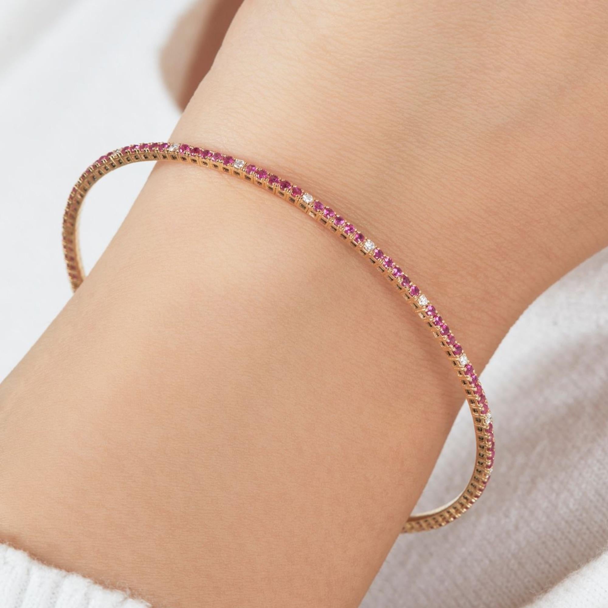 This 18K Gold Diamond Bangle Bracelet features a full eternity flexible bangle set with natural rubies and diamonds in a delicate pave diamond bangle design. This solid gold ruby bangle offers understated uniqueness in a dainty 18K cuff bracelet.