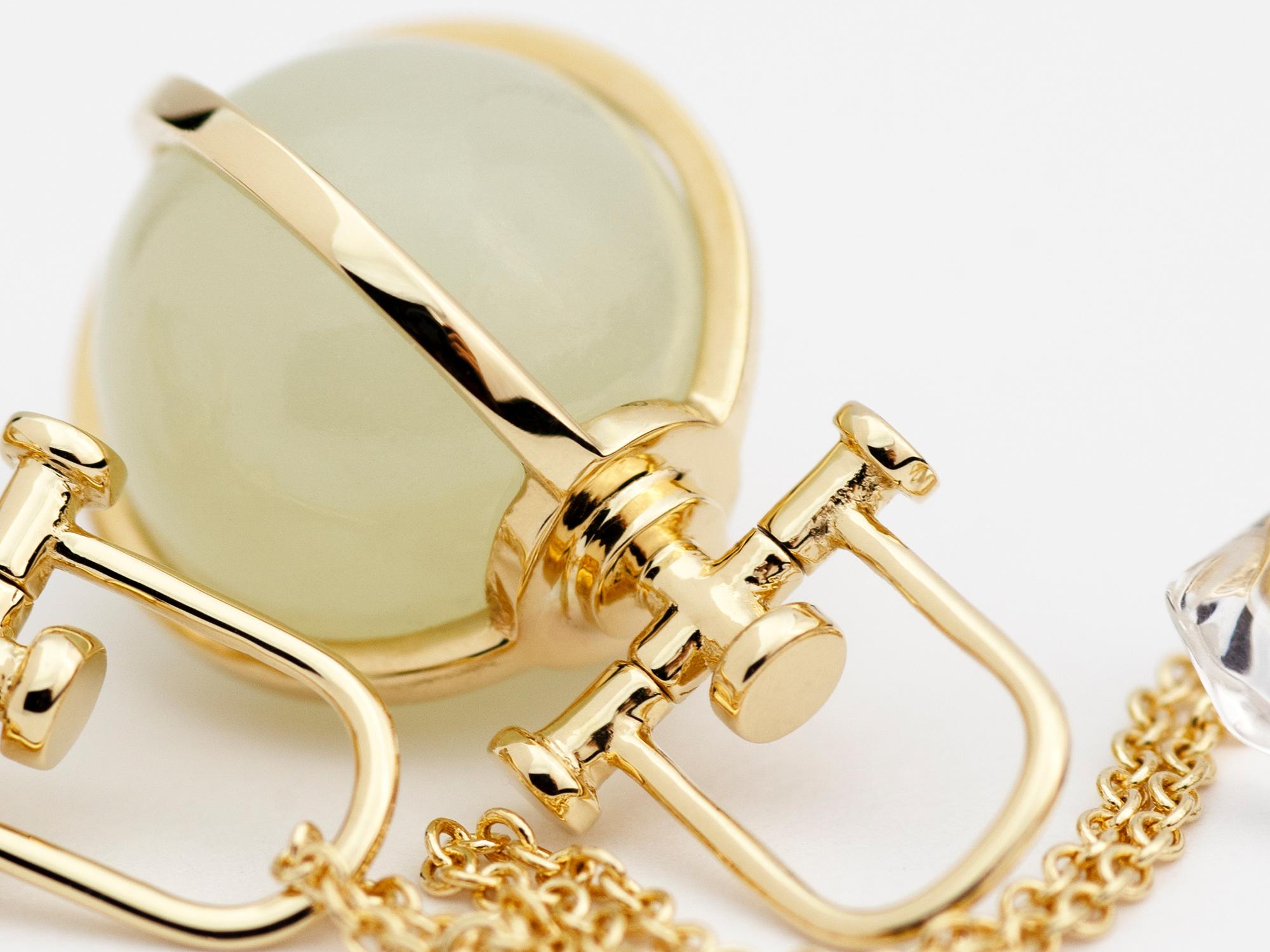 Rebecca Li crée des bijoux sacrés et de pleine conscience. 
Ce collier orbe minimaliste en néphrite et jade blanc fait partie de sa collection Crystal Orb. Le principal élément de conception utilisé est le cercle de la géométrie sacrée. Il