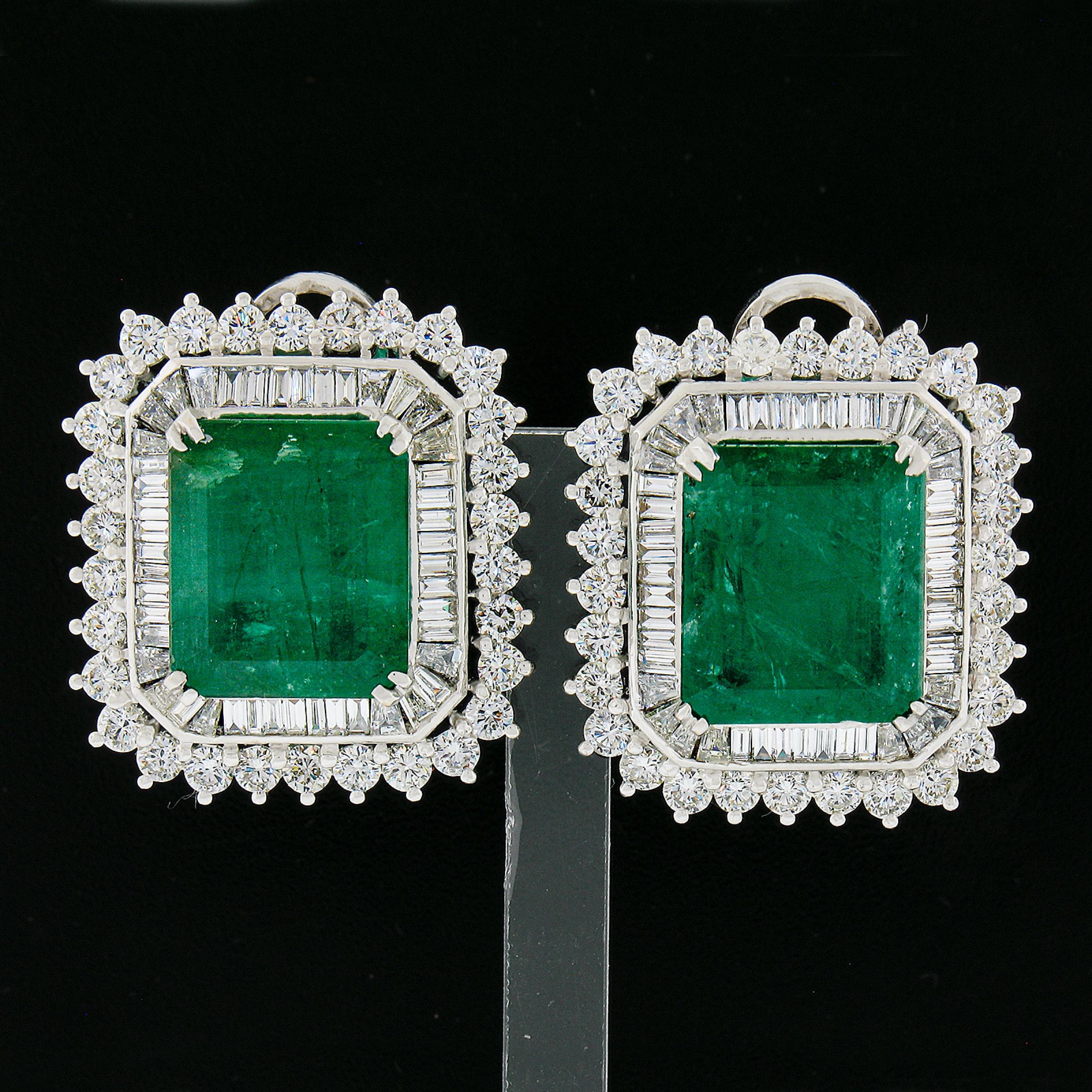 This substantial and large pair of vintage earrings features two large, GIA certified, octagonal step cut emeralds in which together total approximately an incredible 18-20 carats in weight. These stones display an absolutely rich green color that