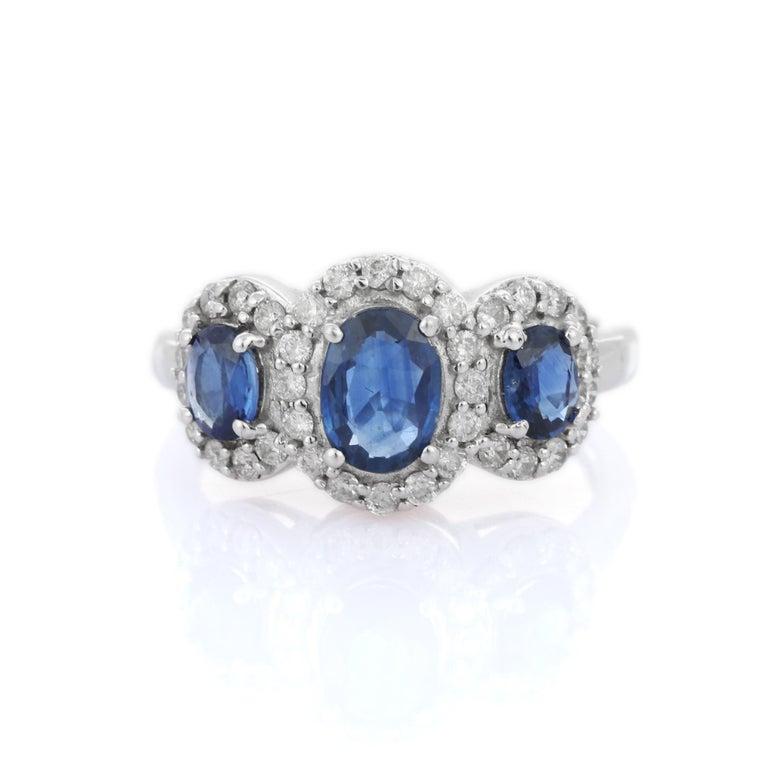 En vente :  Bague de fiançailles à trois pierres en or blanc massif 18 carats avec halo de diamants et saphirs bleus 7