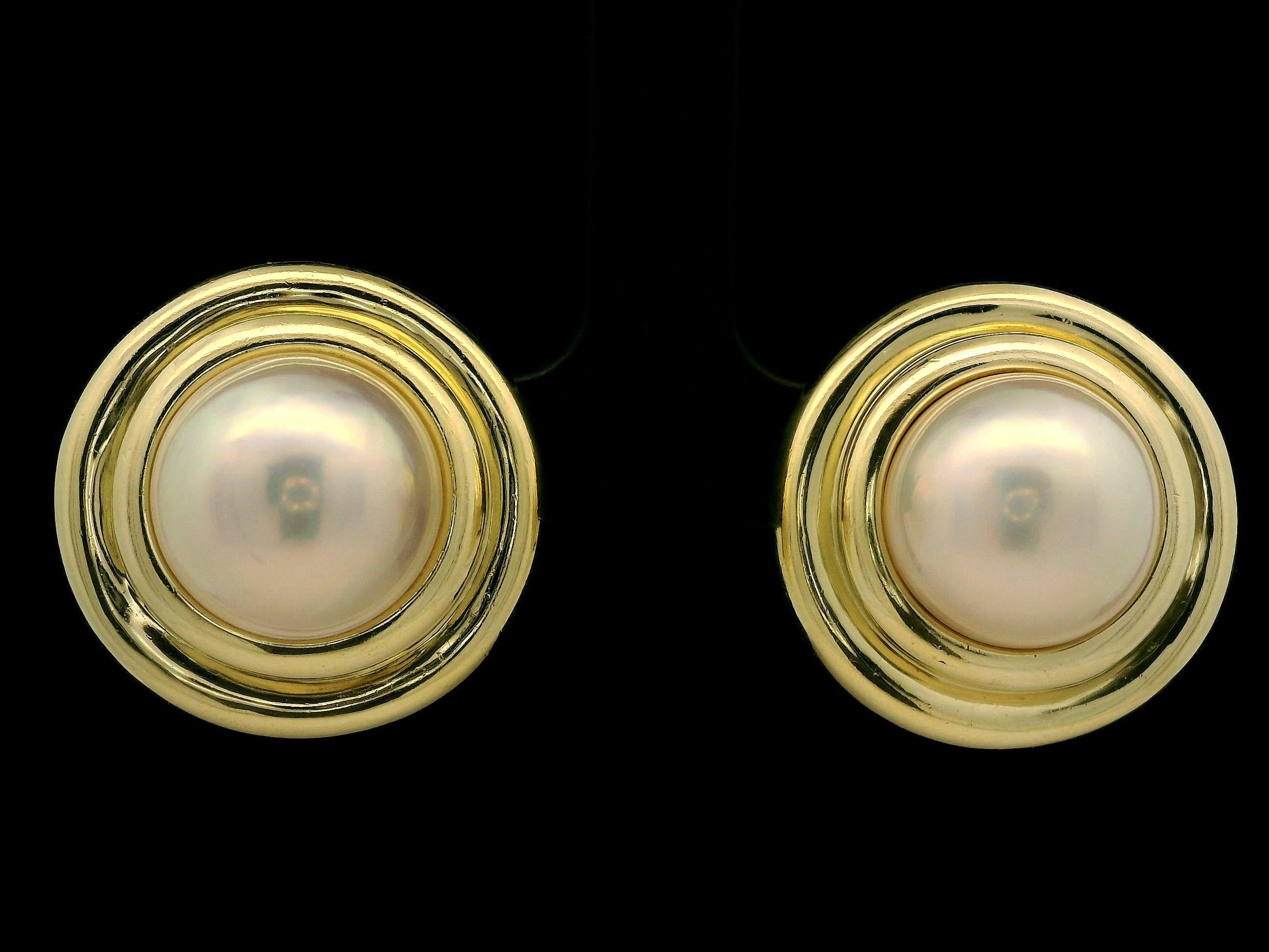 --Pierre(s) :...
(2) Véritables perles de culture Mabe - forme bouton rond - couleur blanche avec reflets roses - beau lustre - 13.8mm chaque (approx.)

MATERIAL : Or jaune massif 18K
Poids : 25,06 grammes
Support : Poteaux avec fermetures en oméga