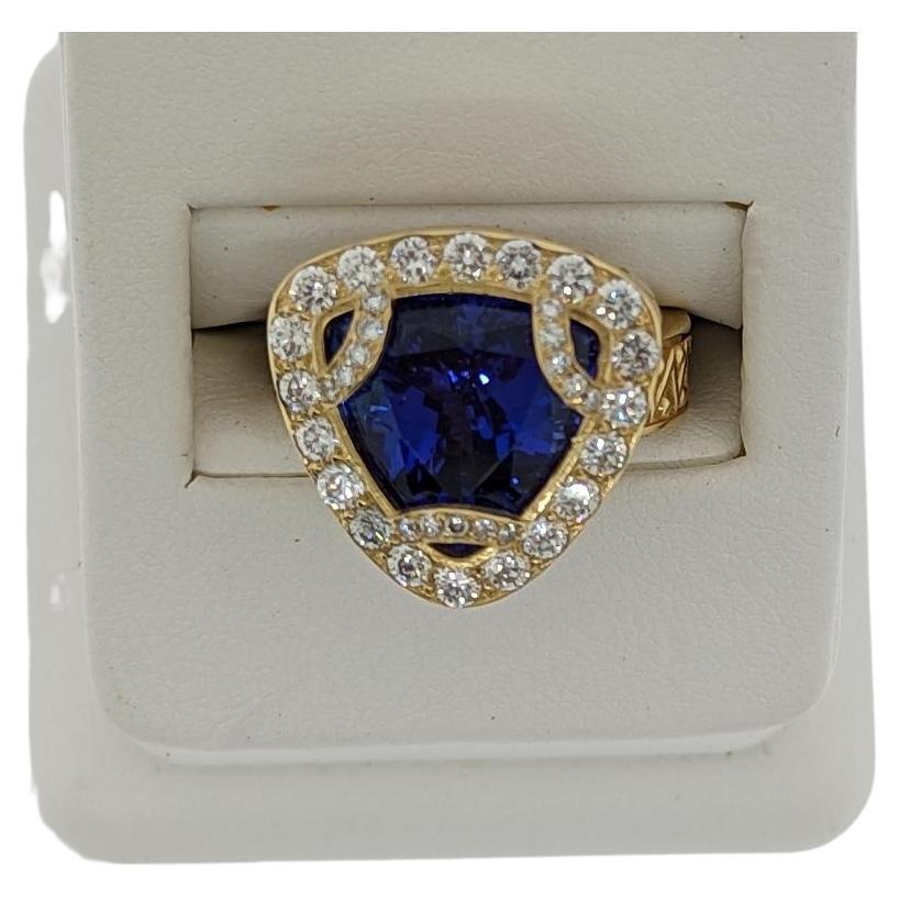 Coming from the mines of Tanzania, the lovely and vibrant Tanzanite gemstone (6.48 cts) comes to life in the mounting.  The triangle cut stone has a diamond accent motif around it's points and is set with diamonds.   Those three diamond motifs each