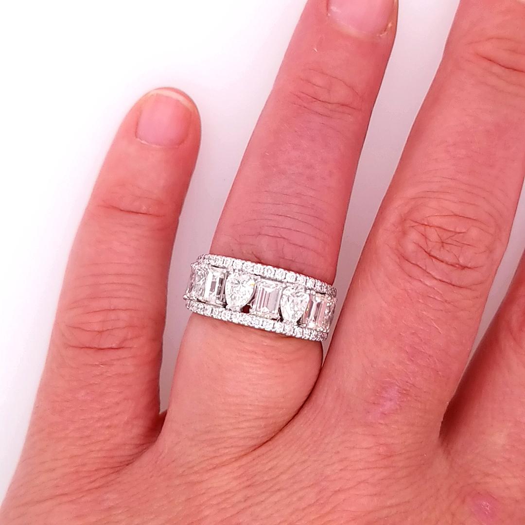 Three row Diamond Band in 18K White Gold.  (38) Round Brilliant Cut Diamonds are set in the two outer rows with the inner band set with alternating (4) Pear Shape and (4) Emerald Shape Diamonds.  The Diamonds weigh approximately 3.58 carat total