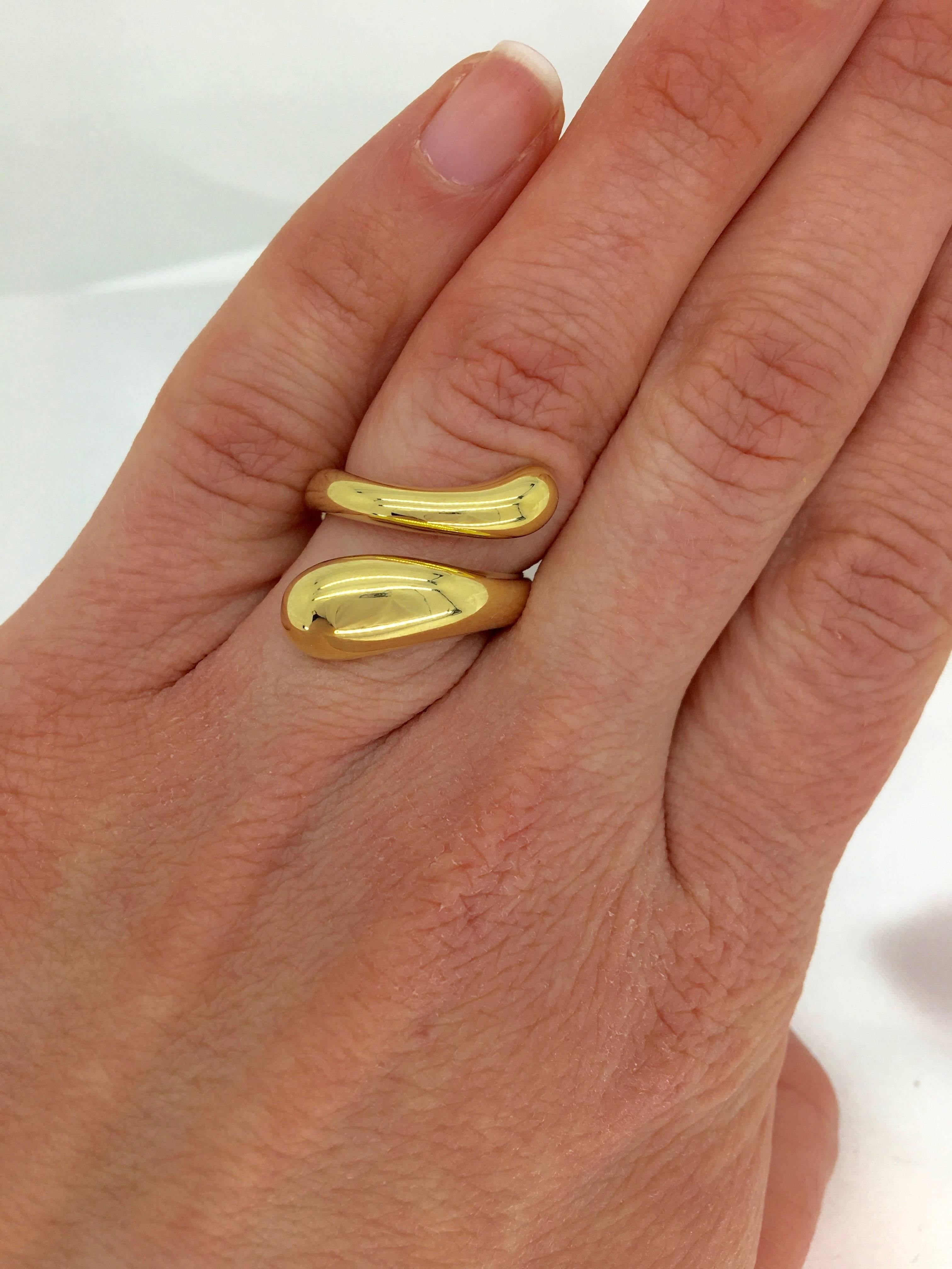 This elegant bypass style Tiffany & Co. ring is Elsa Peretti’s “Teardrop Ring”. The 18K Yellow Gold ring is a size 4 and weighs 15.8 grams. The ring is stamped “Elsa Peretti TIFFANY & CO. 750 SPAIN”.