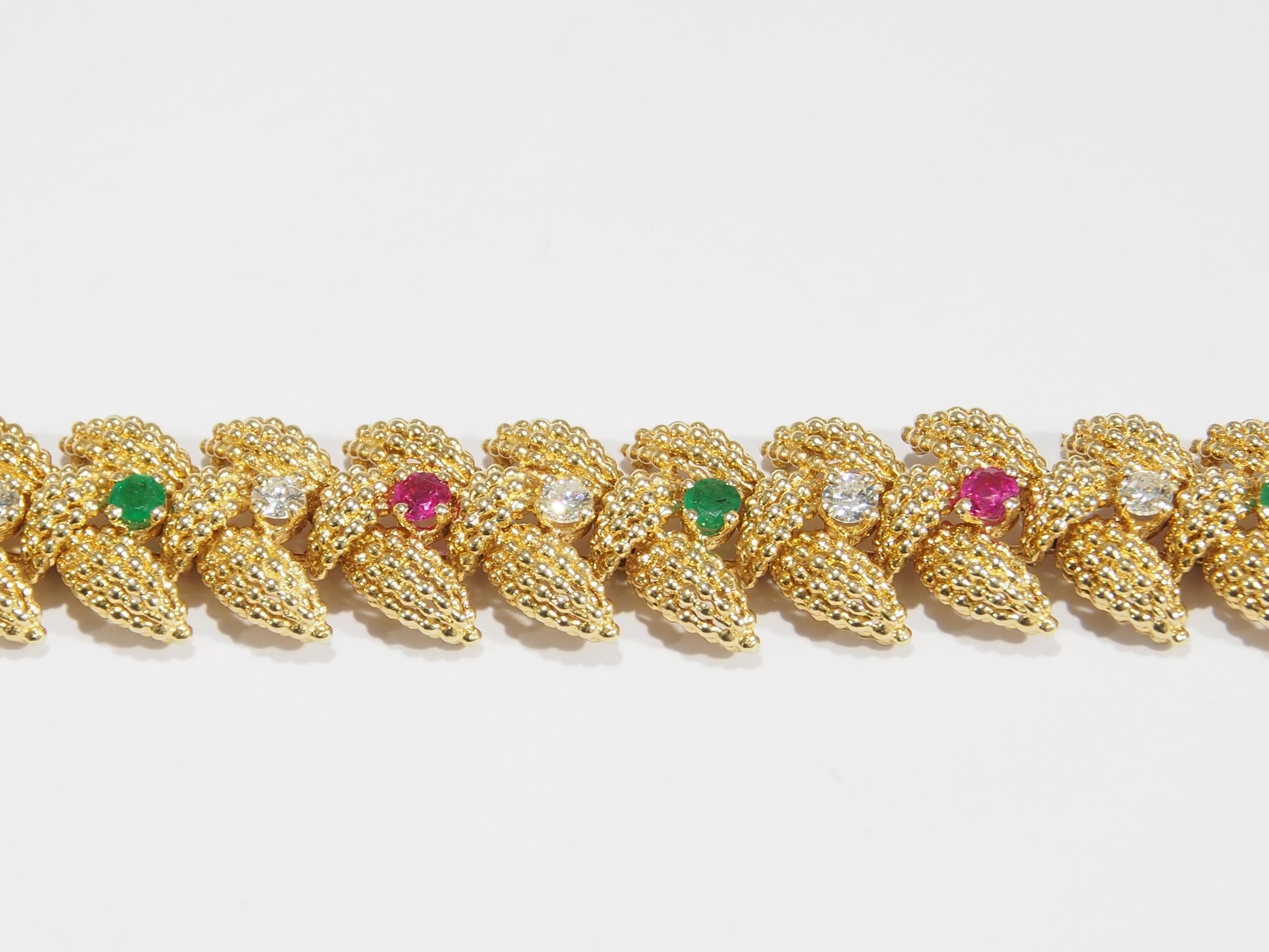 From the iconic jewelry designer, Tiffany & Co. is this stunning Vintage 18K Yellow Gold Link Bracelet. Fabricated with interlocking reticulated Leaves that are accented with alternating Diamonds, Rubies and Emeralds to create a stunning heirloom