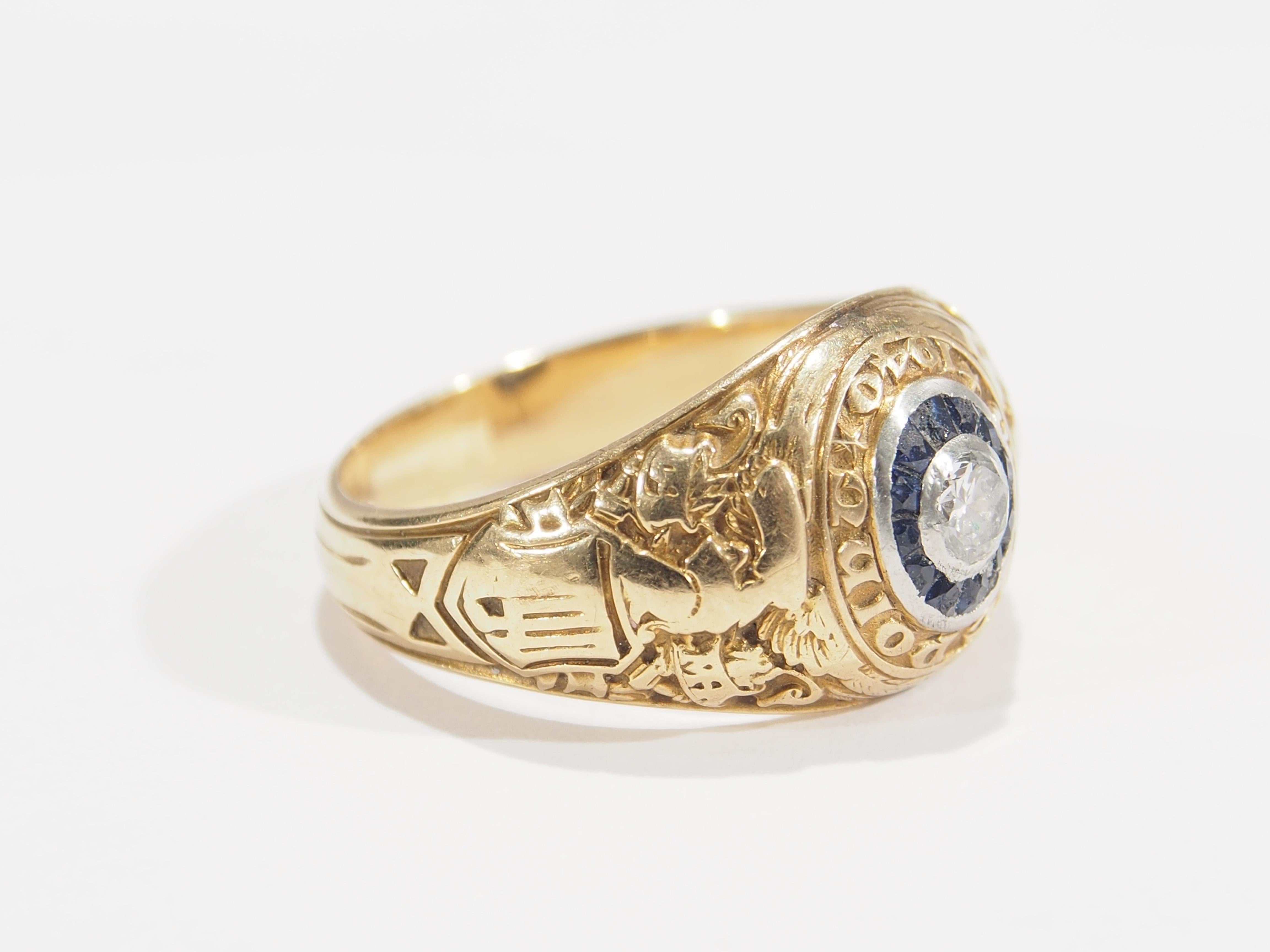 Tiffany & Co West Point Military Class Ring 1940. Featuring (1) Round Brilliant Cut Bezel set G-H color VS clarity Diamond approximately 0.23ct surrounded by (12) Sapphires. A piece of history. Gold weighs approximately 9.80 grams, finger size 8.