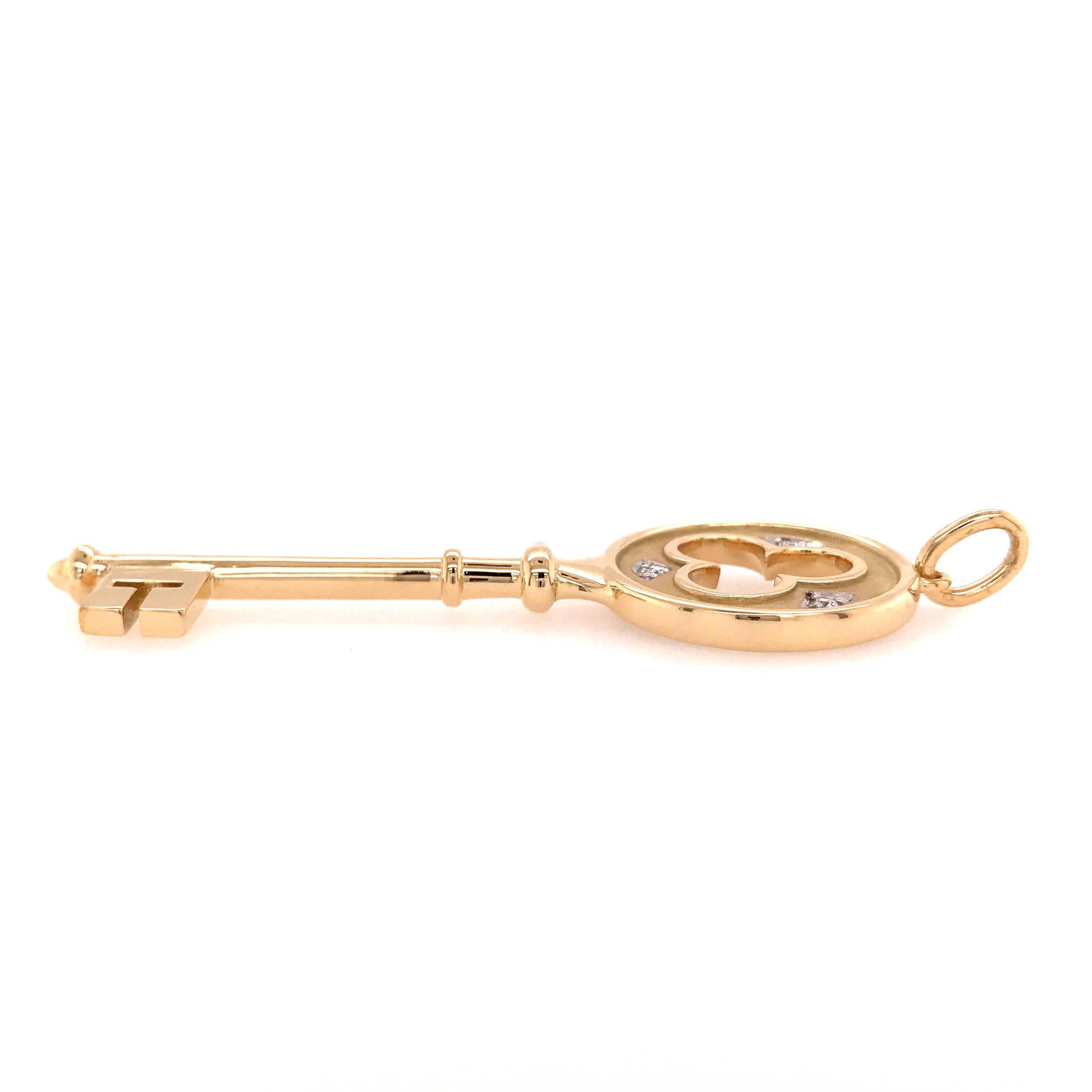 Tiffany & Co. Three-Clover Key Pendant in 18K Yellow Gold.  (3) Round Brilliant Cut Diamonds weighing 0.12 carat total weight, F-G in color and VS in clarity are prong set around the three-leaf clover.  The key measures 2 1/4 inch in length and 3/4