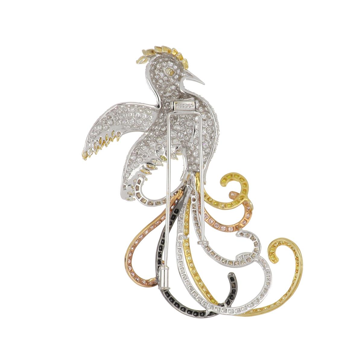 Phoenix brooch composed of 18K white, yellow, pink, and blackened gold with over 400 diamonds that total 9 carats.  The body of the phoenix is primarily white diamonds, accented with marquise shaped colored diamonds, and the tail feathers are pink,