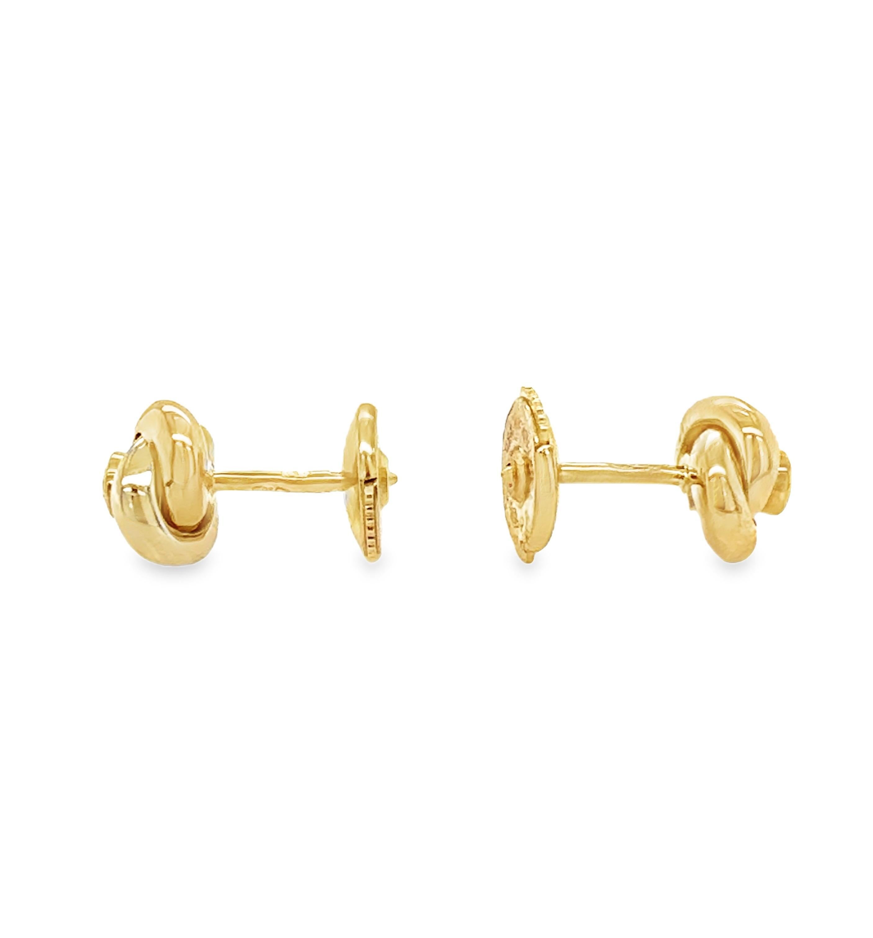Estos elegantes pendientes Cartier de oro tricolor de 18 quilates presentan un intrincado motivo de nudo elaborado en oro blanco, amarillo y rosa, que simboliza la sofisticación atemporal. En el centro de cada pendiente hay dos diamantes redondos de