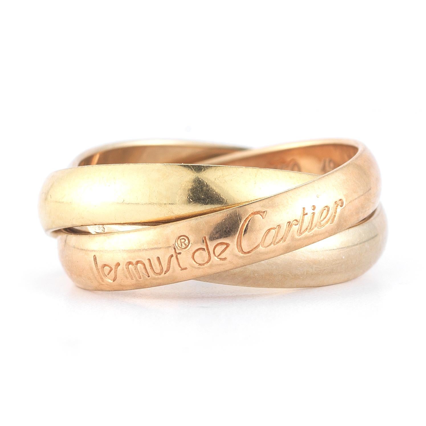 Tri-Color Gold Les Must de Cartier Trinity Band Ring with 18 karat yellow gold, rose gold and white gold interlaced bands each measuring approximately 3.5mm is signed Cartier A4492V. Finger size 4.75. Pink, yellow and white gold symbolize love,