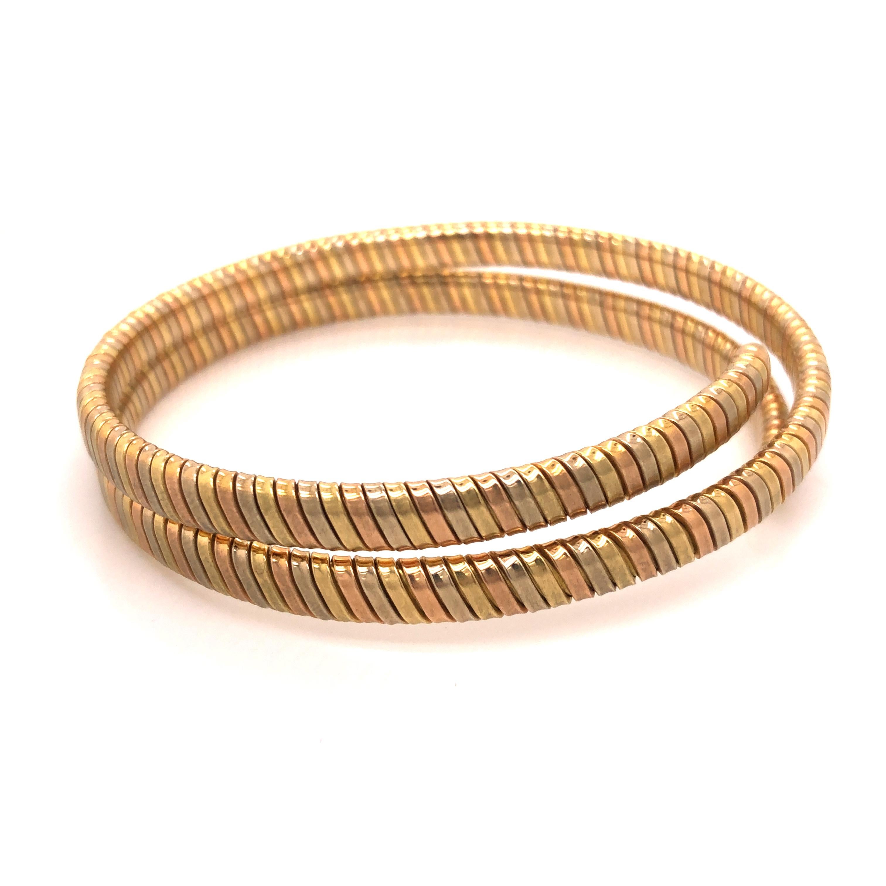 A vintage spiral flexible Italian bangle bracelet crafted from yellow, white, and rose gold. The bracelet has a matte finish on the outside and plotted finish on the inside. Marked 750 and having Italian maker's mark 740 VI corresponding to Essepi