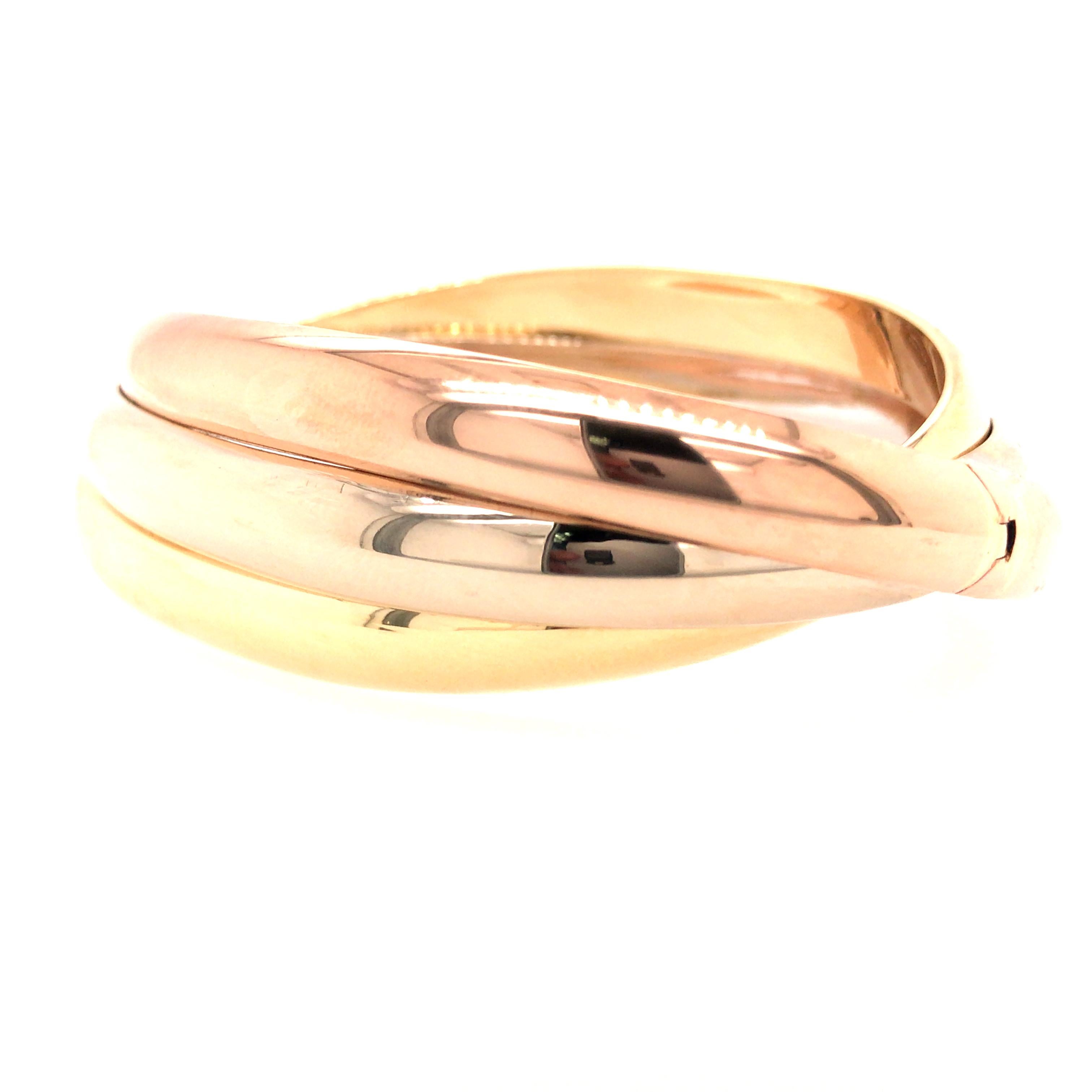 18K Tri-Color Gold Twist Bangle.  The Bangle measures 6 1/2 inch inner circumference and 7/8 inch in width.  Hinged opening.  54.42 grams.