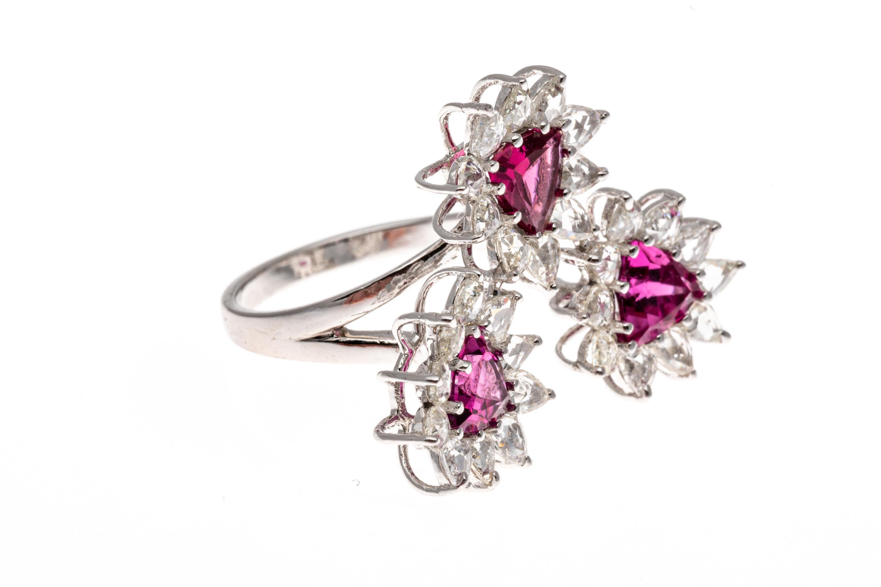 18k white gold ring. This absolutely beautiful ring contains three flower clusters, each set with a center, trillion faceted, dark bright pink color pink tourmaline, approximately 1.50 TCW, and prong set. Framing each pink tourmaline is a pear