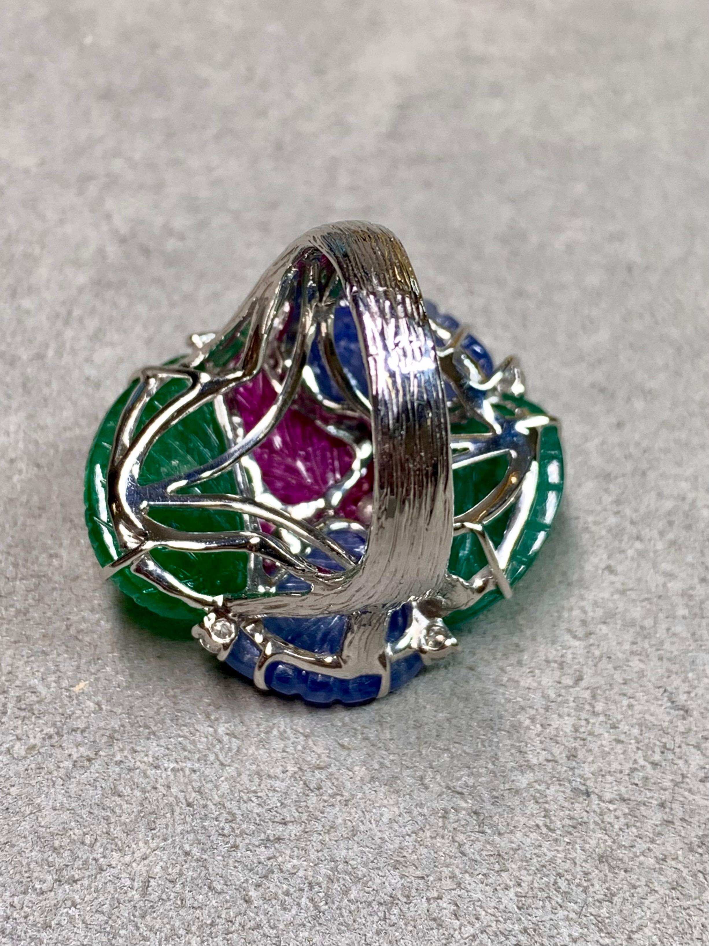 Ein bemerkenswerter Edelstein-Cocktailring aus reich strukturiertem 18-karätigem Weißgold, besetzt mit einem lebhaften Strauß handgeschliffener Edelsteine. Im Mittelpunkt des Rings steht ein tief gesättigter Rubin, umgeben von geschnitzten Smaragd-